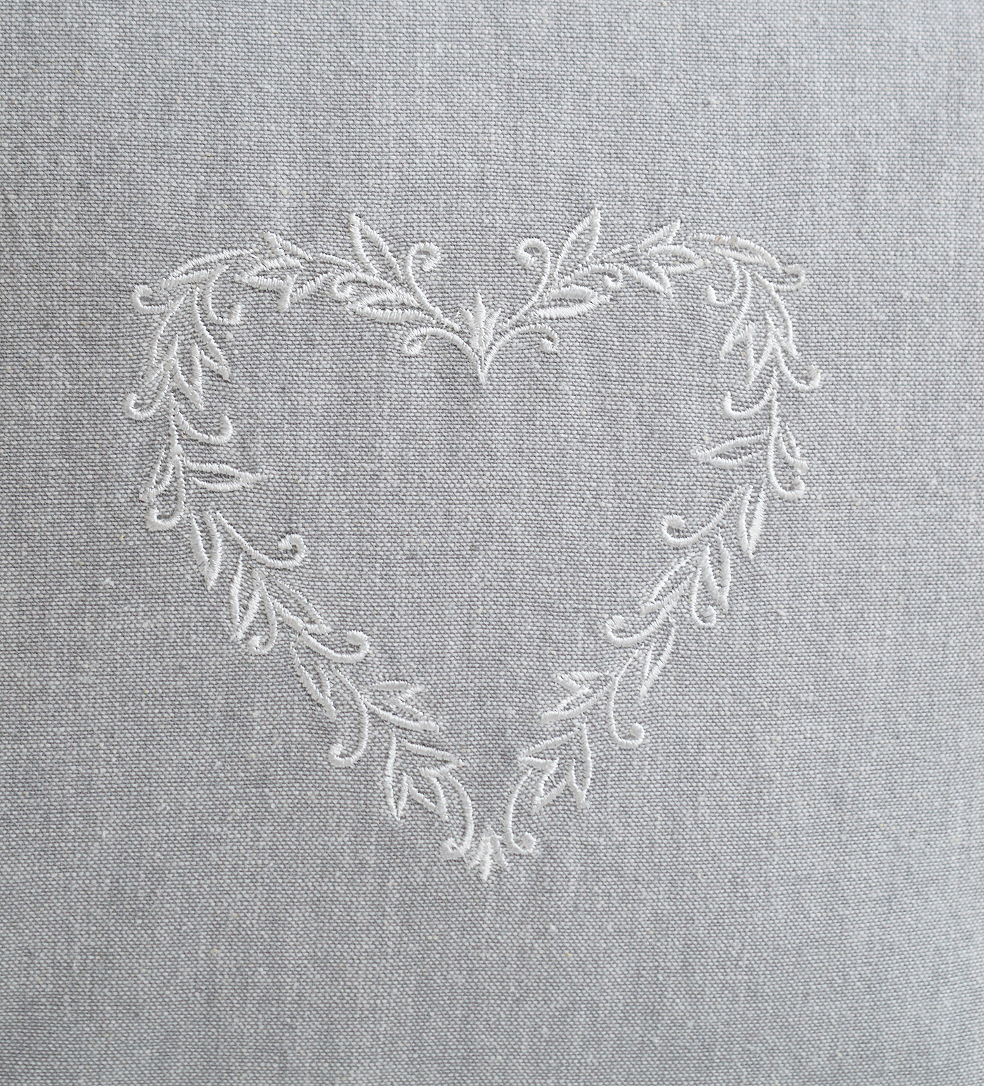 Soft grey throw pillow featuring stitched heart design for cottage interiors