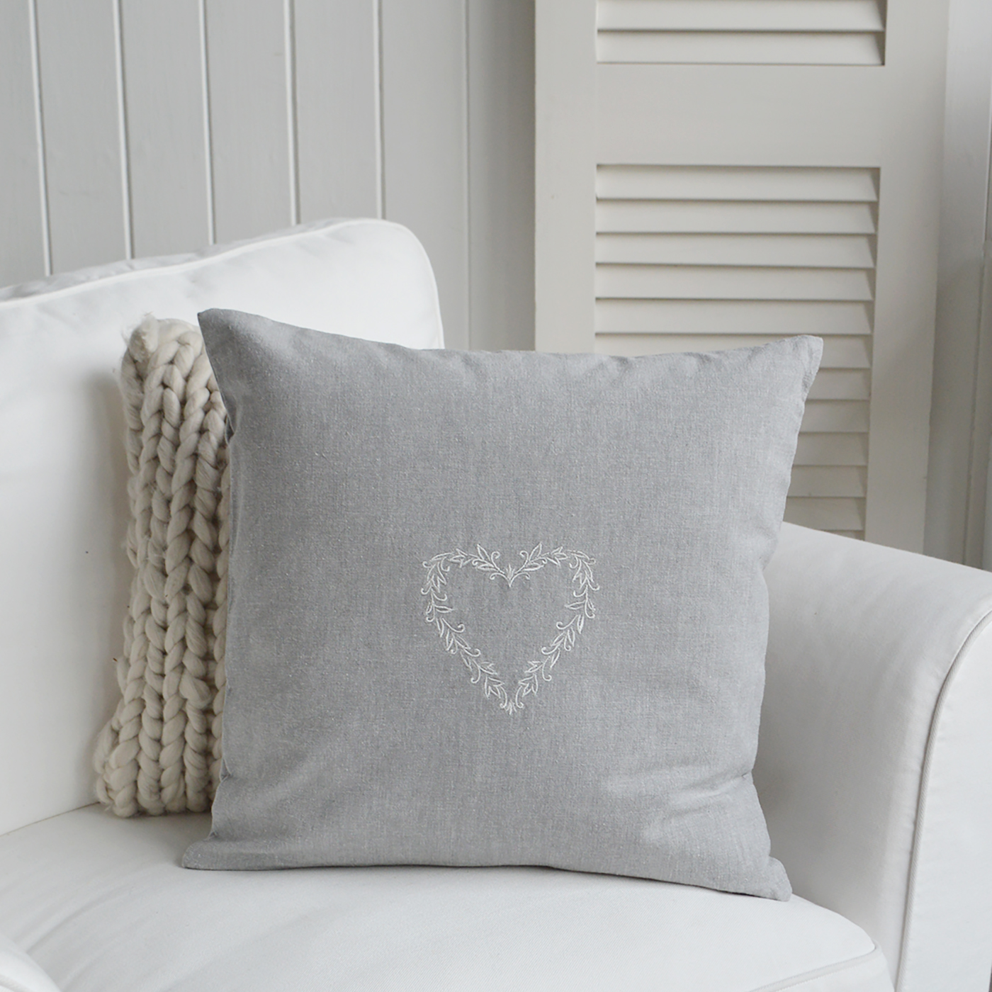 Embroidered heart cushion in grey fabric styled in nautical-themed room