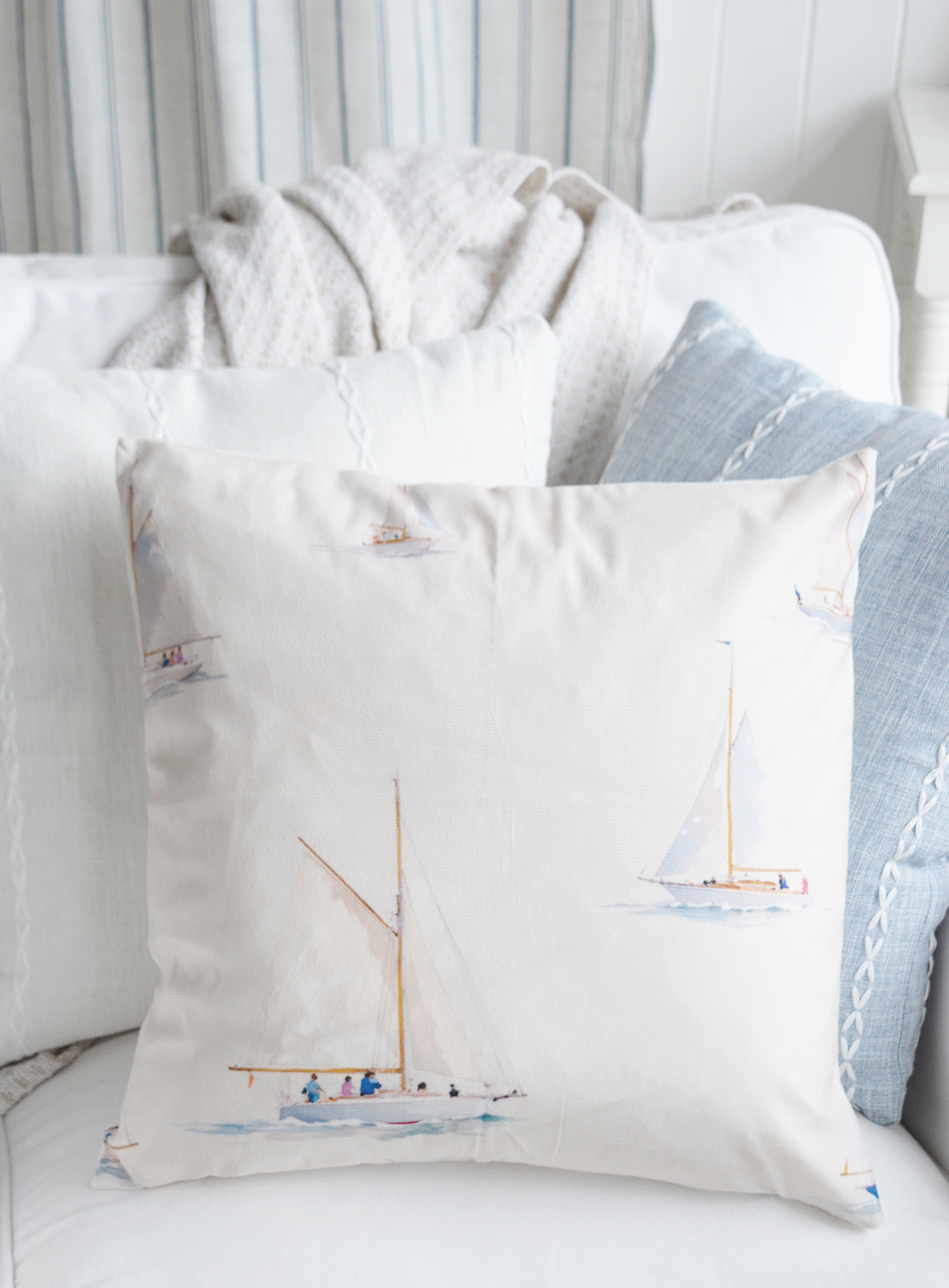 Nautical-inspired sailboat cushion adding gentle coastal detail to a space.