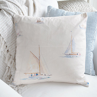 Ivory sailboat cushion adding relaxed seaside charm.