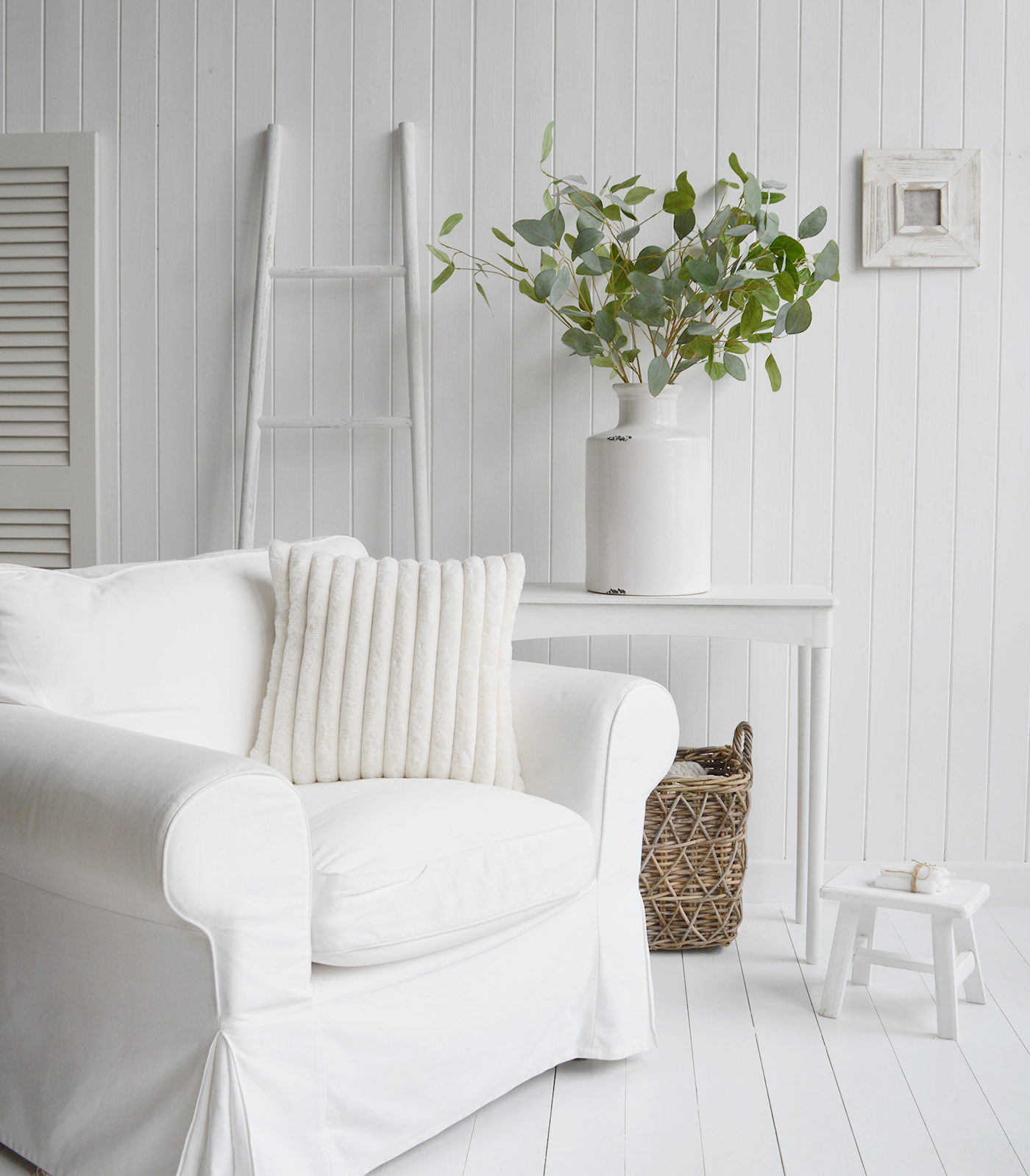 White New England furniture and home decor pieces. Items include Cape Ann white consoles, white ladder, Jackson white cushion cover, white weston photo frame and large white vase