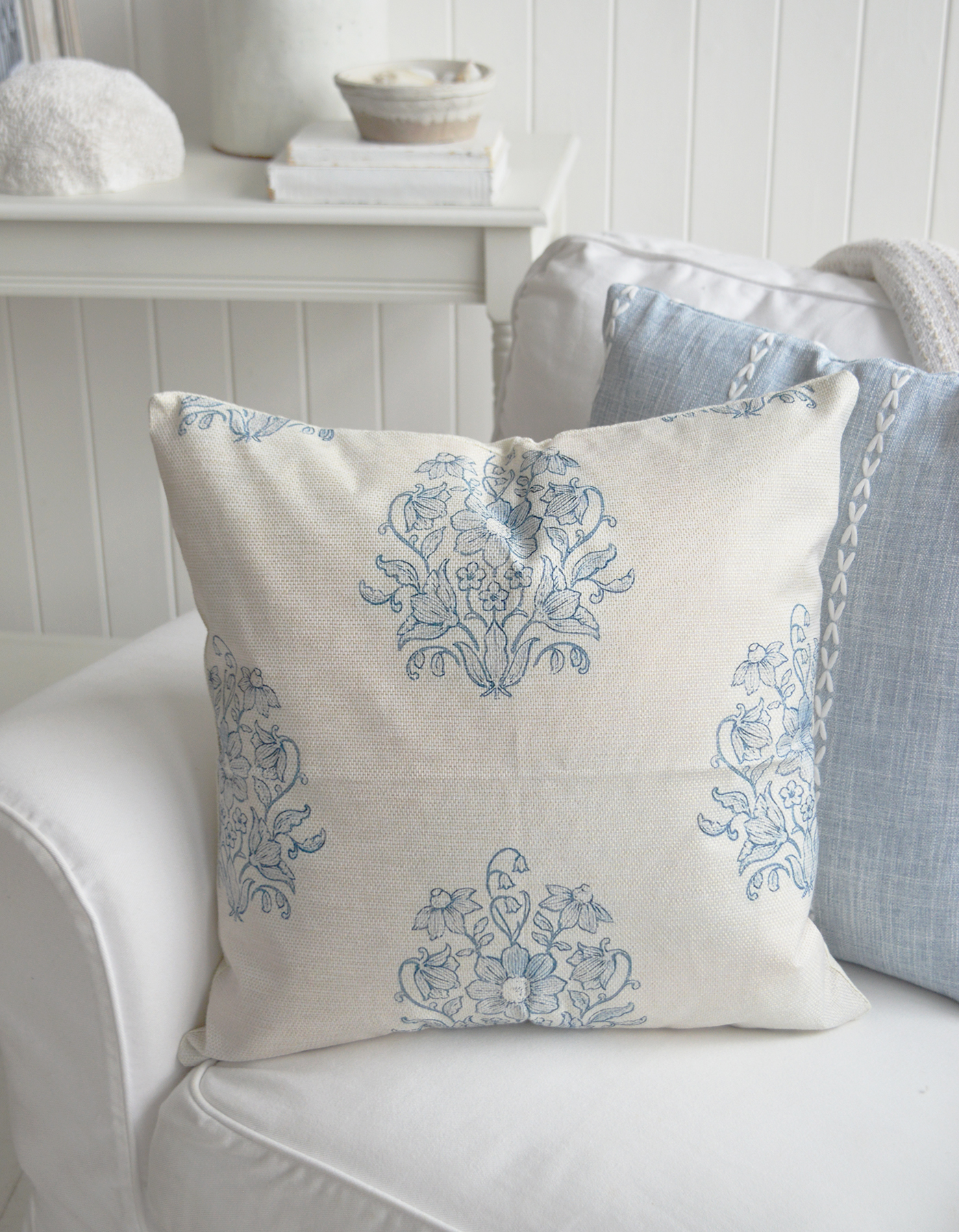 The Meredith Cushion adds a touch of New England coastal style with its beautiful blue floral detailing and soft neutral tones