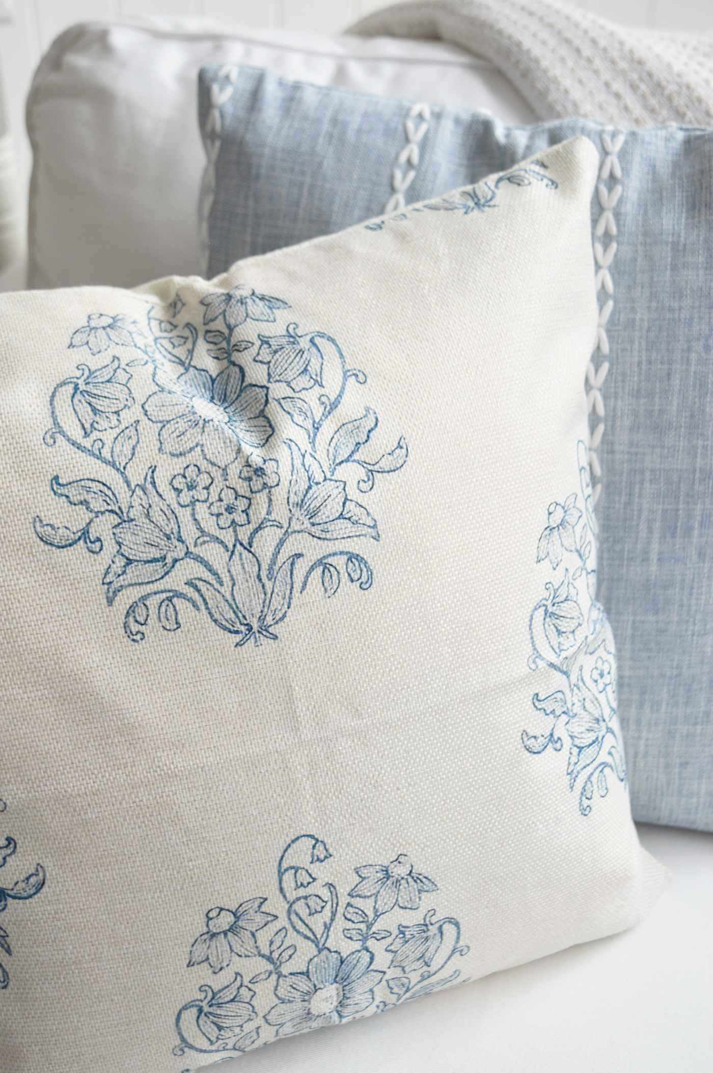 Perfect for coastal homes and beach-house interiors, this floral cushion pairs effortlessly with white linens and natural textures.