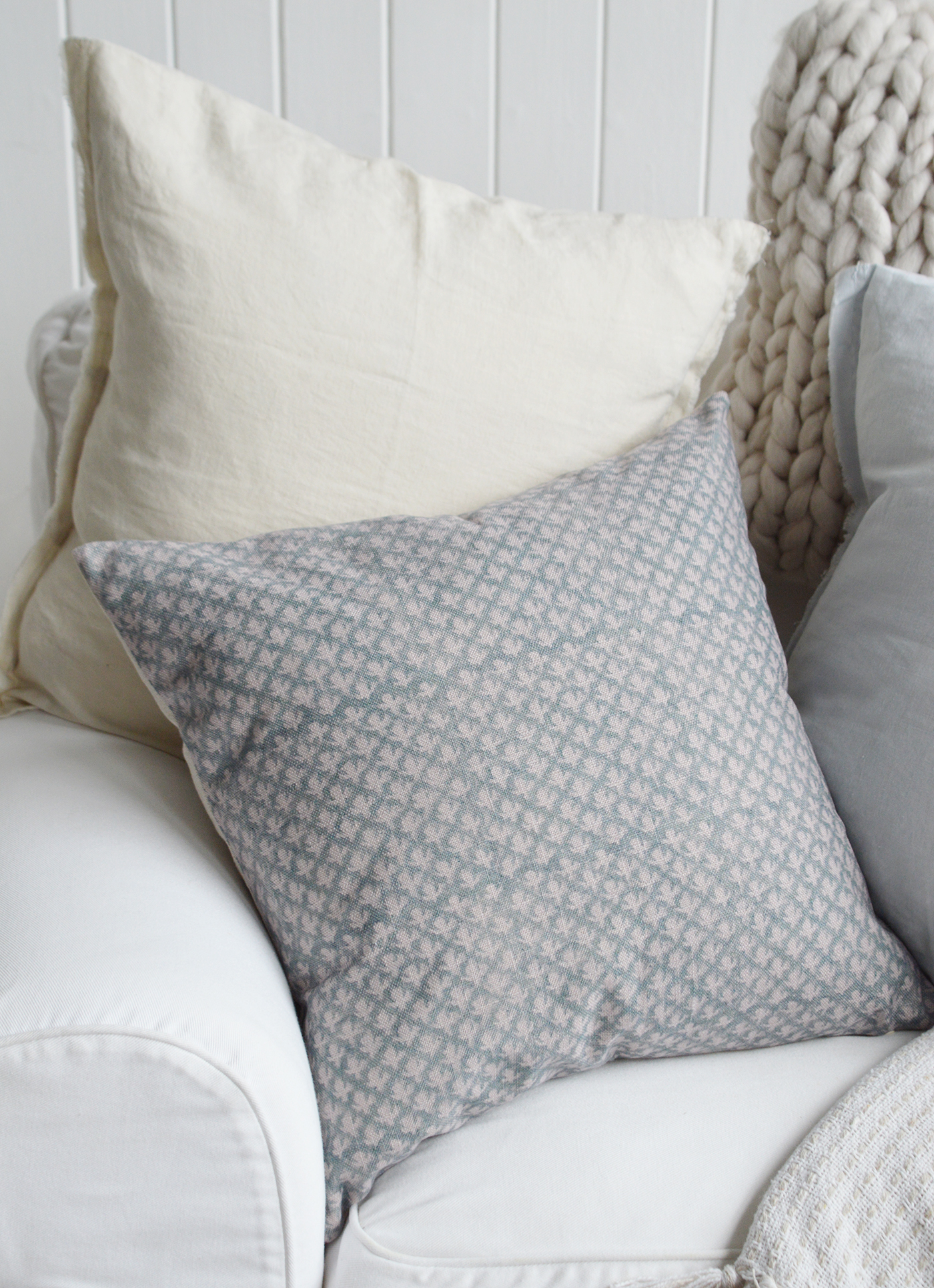 Elegant luxury cushion layered with neutral pillows in a Hamptons home