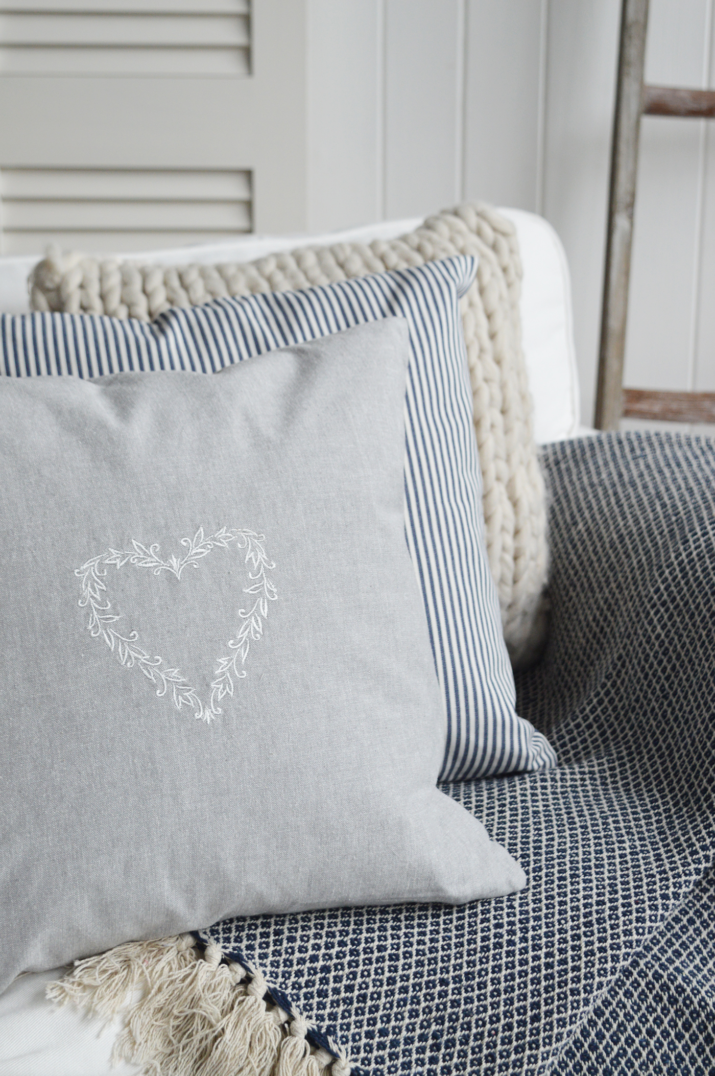 Close-up of embroidered heart detail on grey cushion for coastal home styling