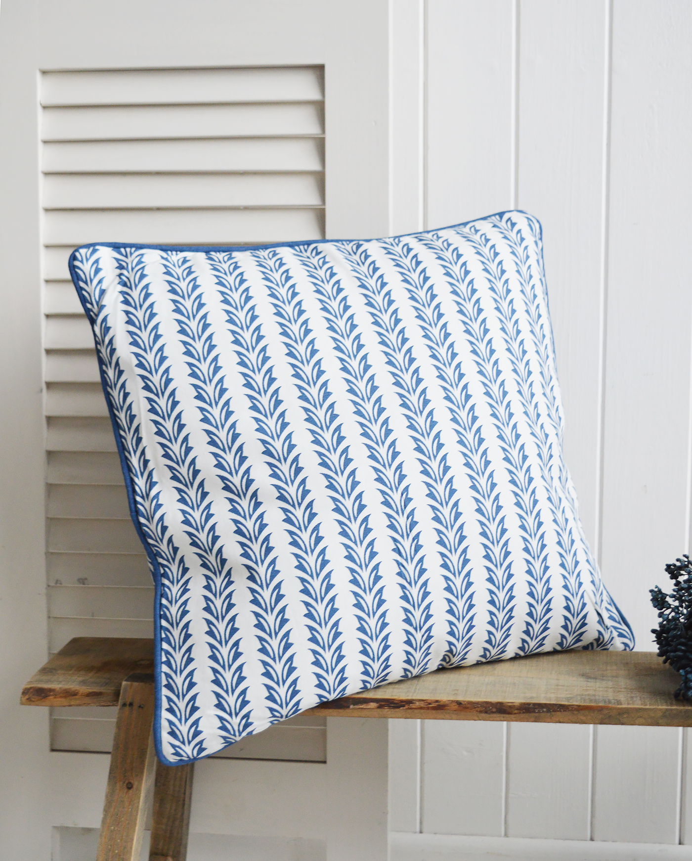 Soft cotton cushions in shades of marine blue and white lend a relaxed, oceanfront elegance to the room.