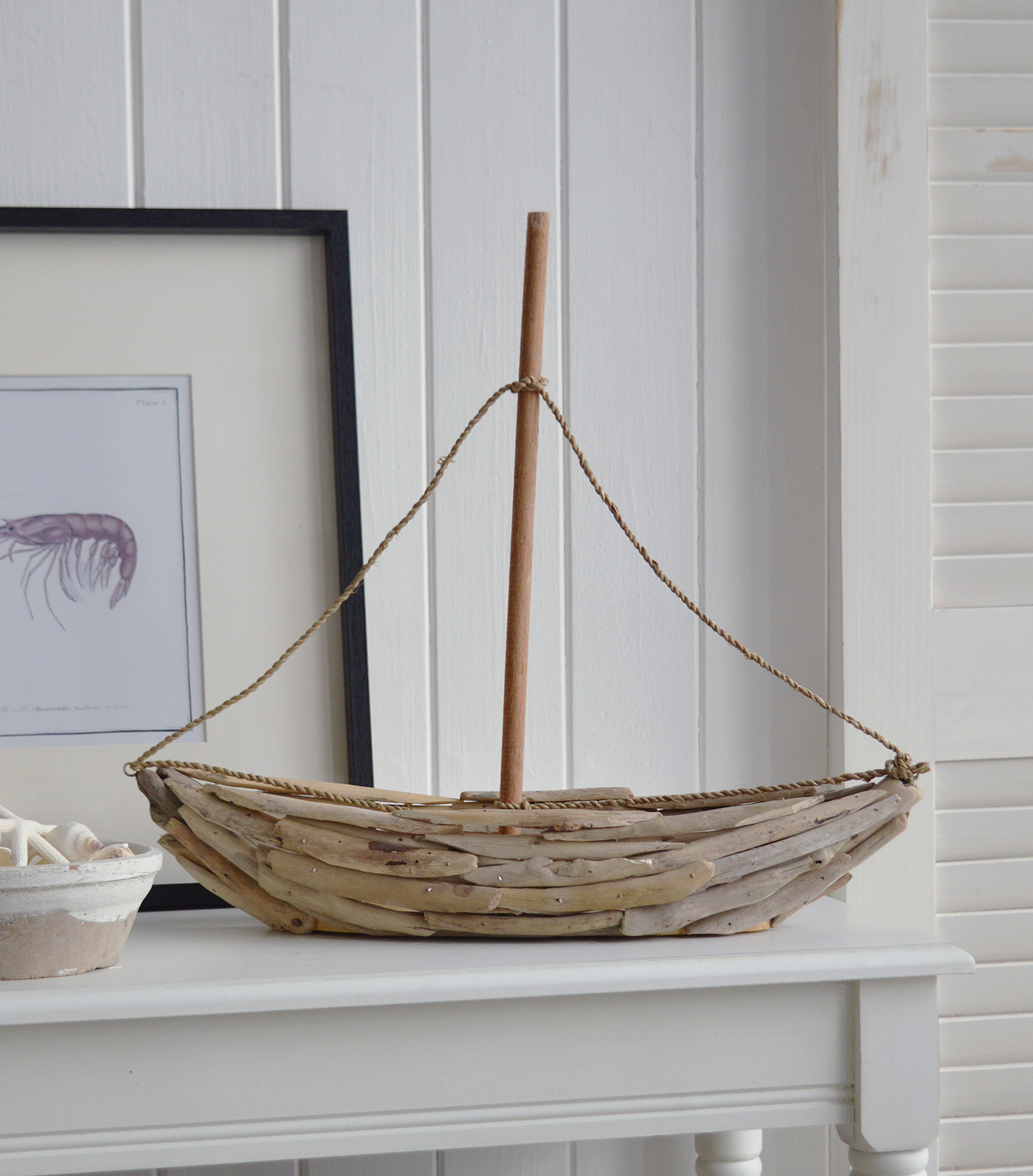 Rustic driftwood yacht ornament with wooden mast and rope detailing in beach house style