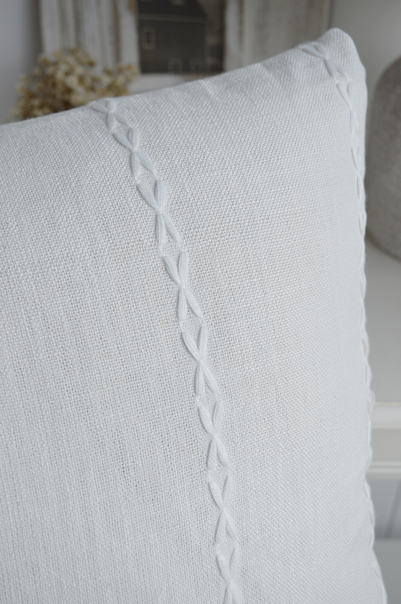White decorative cushion adding gentle texture to a calm coastal interior
