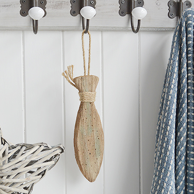 A hanging distressed wooden fish for coastal interiors and homes