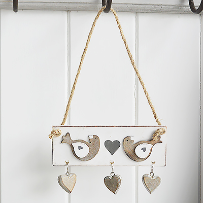 A hanging distressed wooden bird and hearts decor for countryinteriors and homes