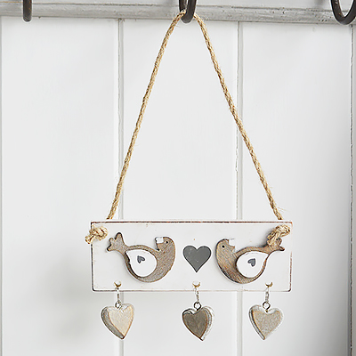 A hanging distressed wooden bird and hearts decor for countryinteriors and homes