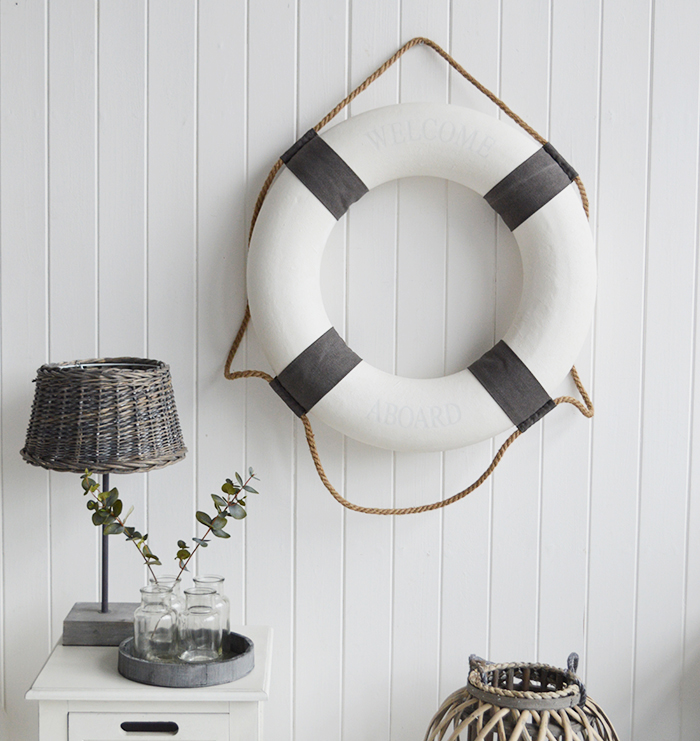 A white and grey vintage style lifebuoy.

The complementing grey and white along with the natural rope and subtle Welcome Aboard offer a touch of Coastal Chic decor to your room