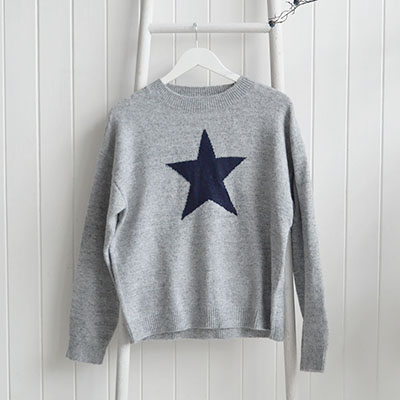 Bring a relaxed New England feel into your everyday wardrobe with our White Lighthouse Star Knit Jumper. Designed in a soft grey tone with a bold navy star, this timeless piece captures the effortless charm of coastal living while remaining versatile enough for any setting.