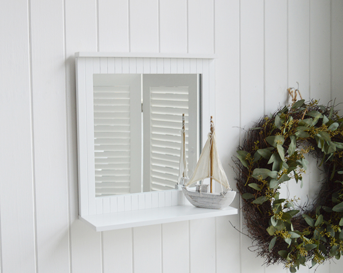 White bathroom mirror with a shelf for decorating a white bathroom in New England style 