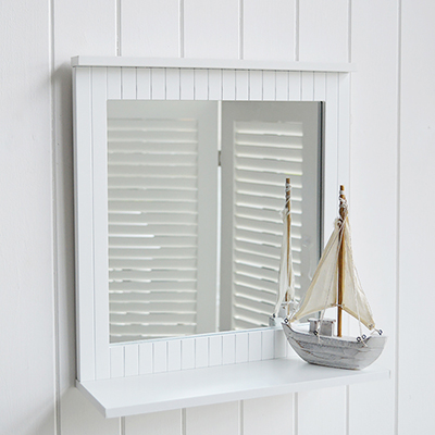 A white bathroom mirror with a shelf.    Ideal in any bathroom with the traditional clapboard finish, but works perfectly with our New England inspired homes by the coast, in the country or a city dwelling.