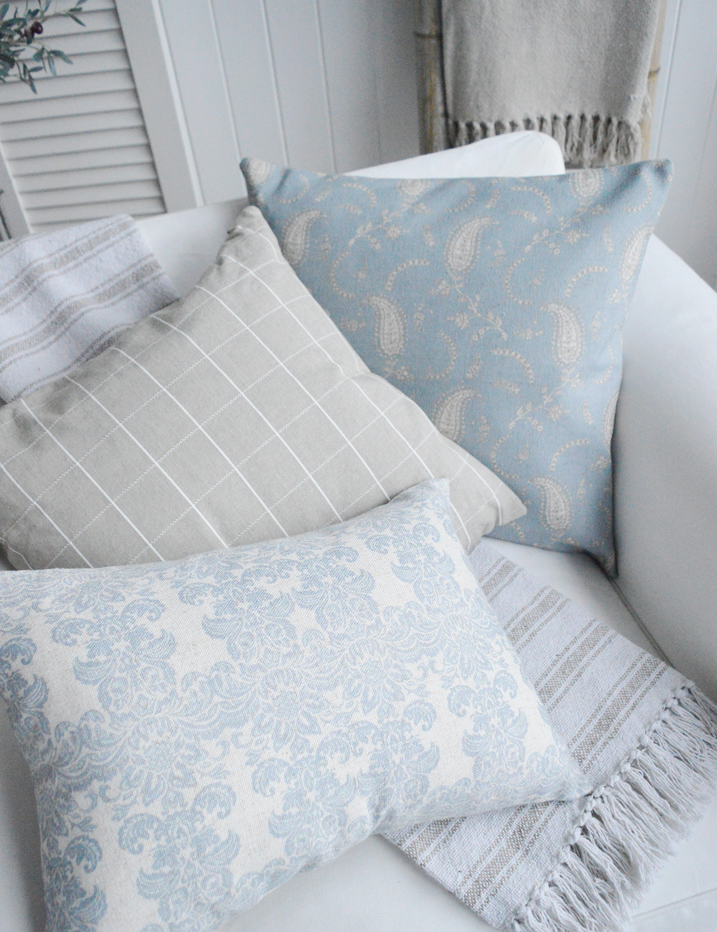 Coastal cushions and throws in blues and taupes for a luxury Hamptons beach house home and interior