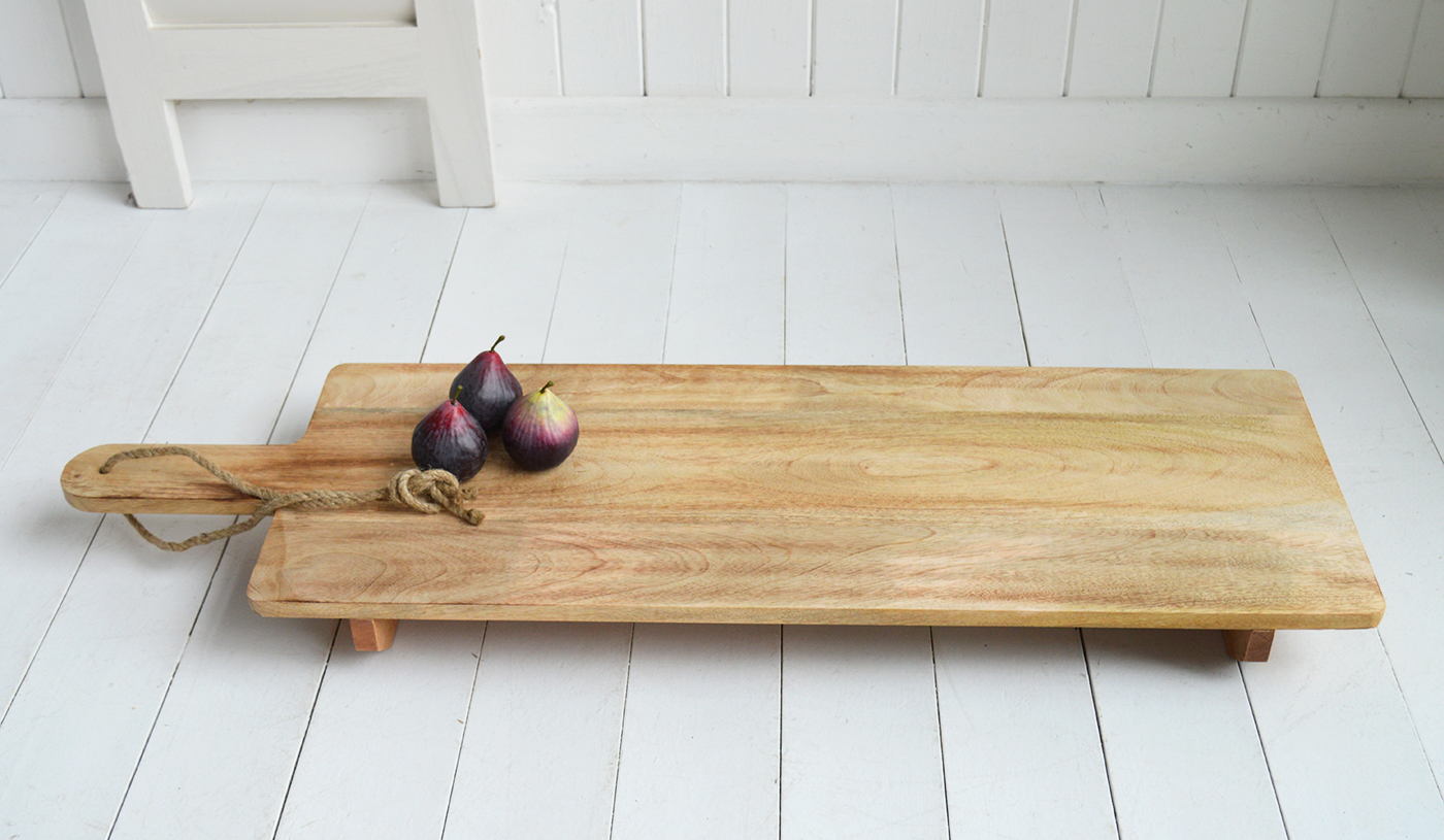 Leaning against the wall when not in use, this beautifully crafted wooden paddleboard doubles as both a decorative accent and a functional serving piece.