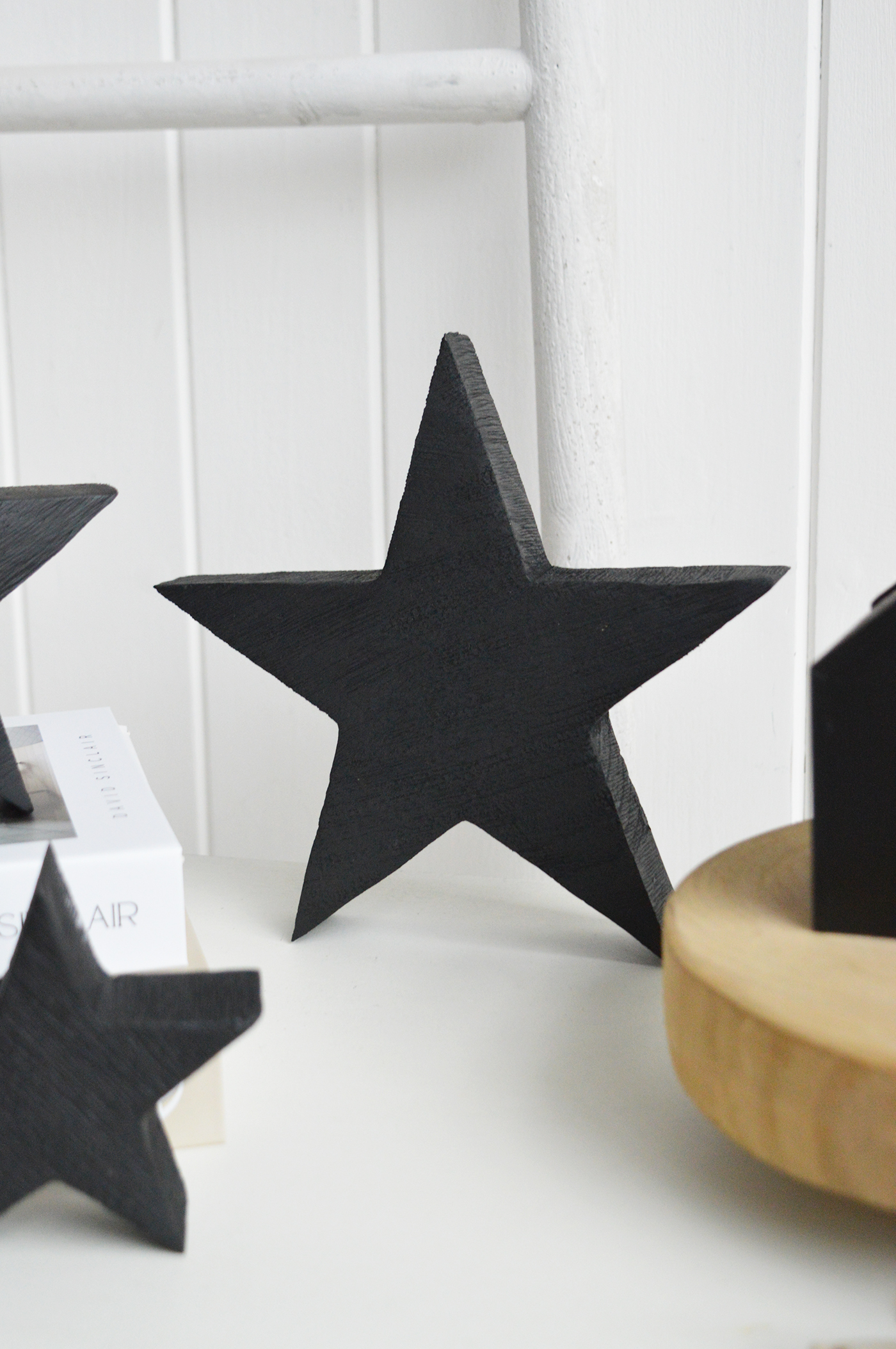 The wooden balck stars are Perfect for layering on shelves and consoles in relaxed coastal interiors inspired by the New England shoreline.