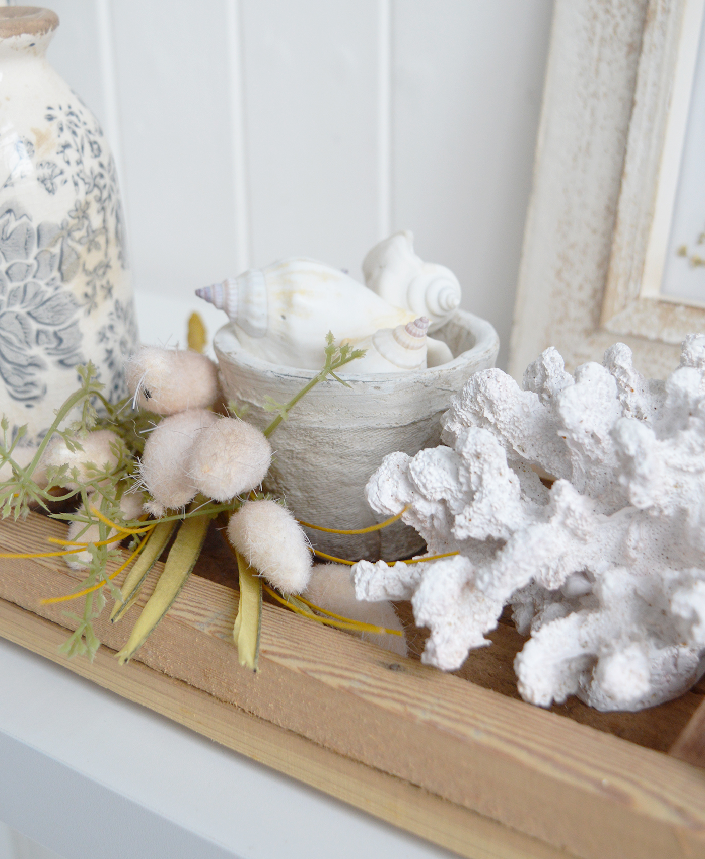 Decorative shells and white faux coral introduce subtle seaside details to neutral home décor.