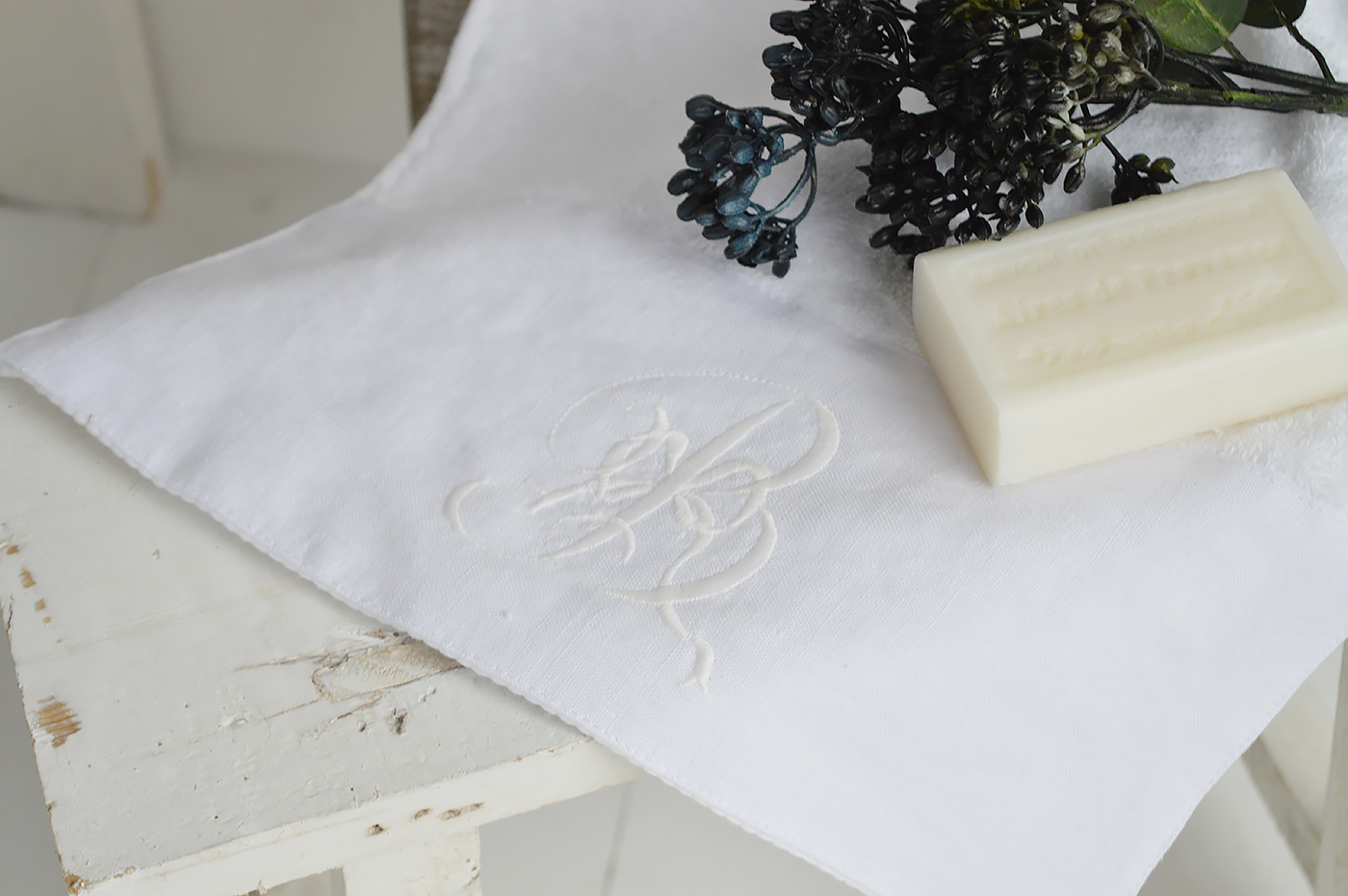 A white embroidered guest towel with monogram