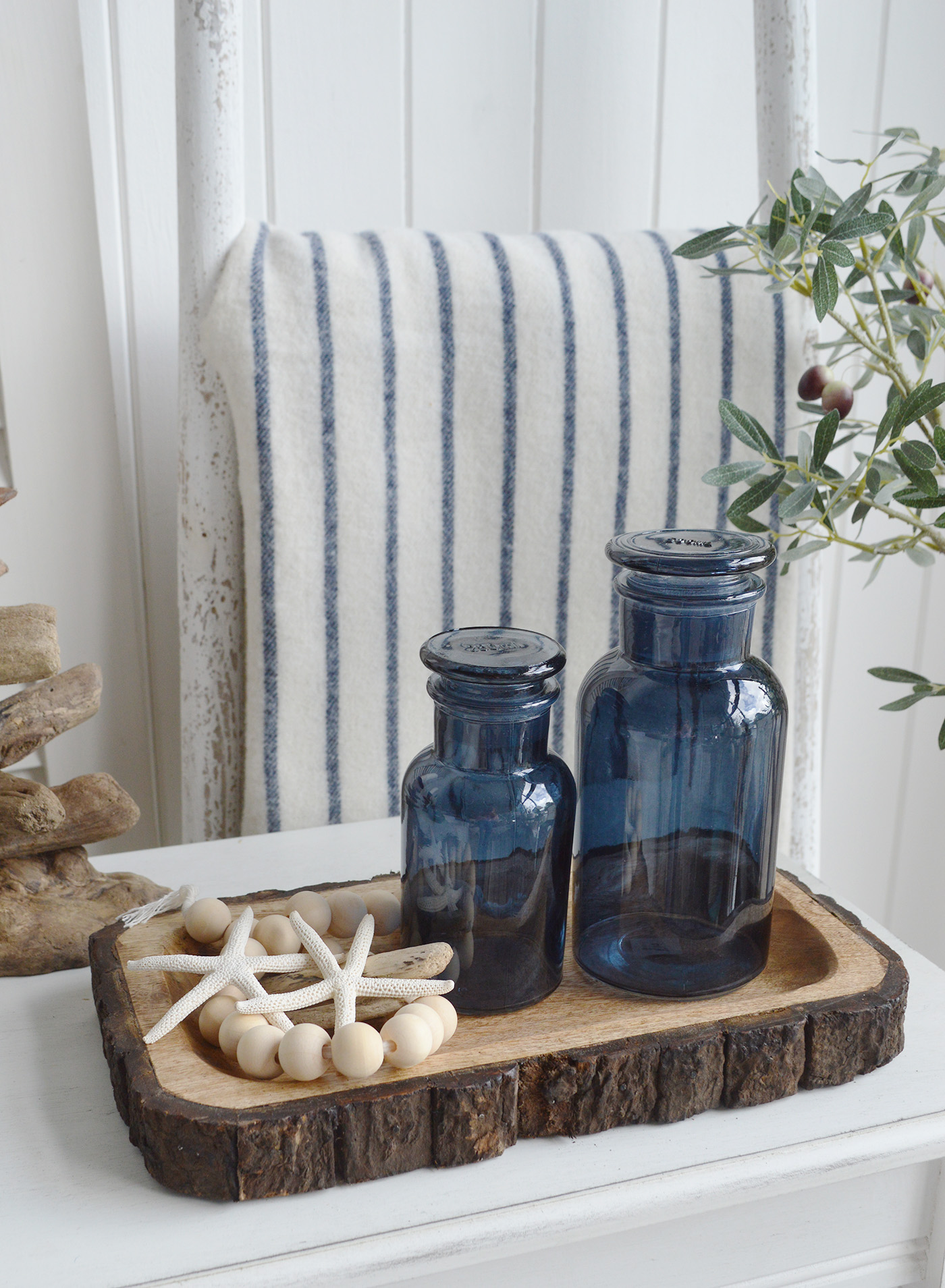 Decorative Blue glass bottles on the tree trunk rustic tray for New England style living in coastal and country homes and furniture