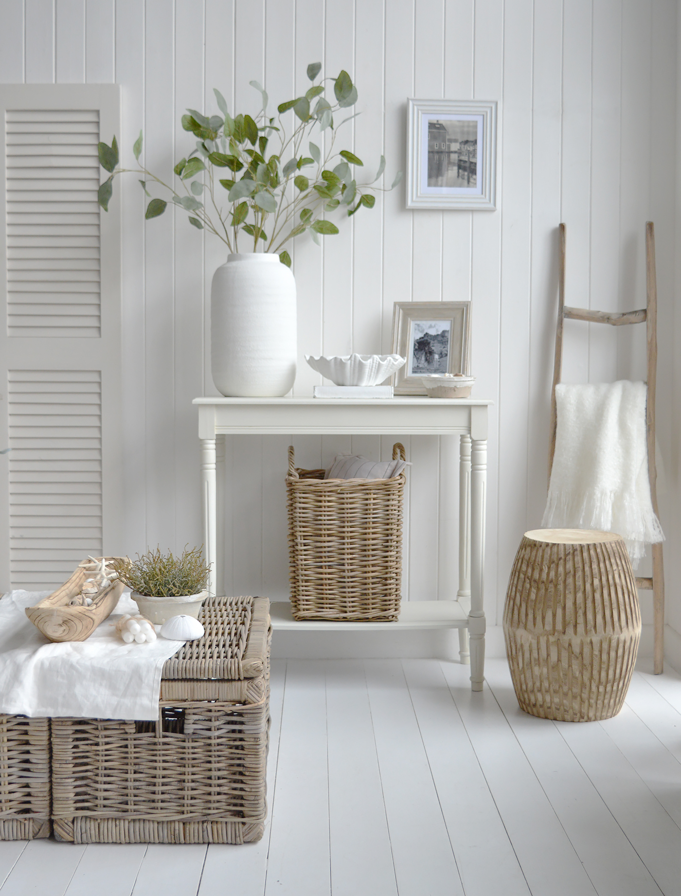 A coastal inspired living room in all white and natural wood for a luxury Hamptons feel