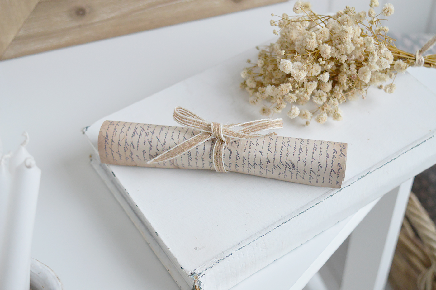 Decorative vintage paper scroll styled on coffee table books in coastal interiors.