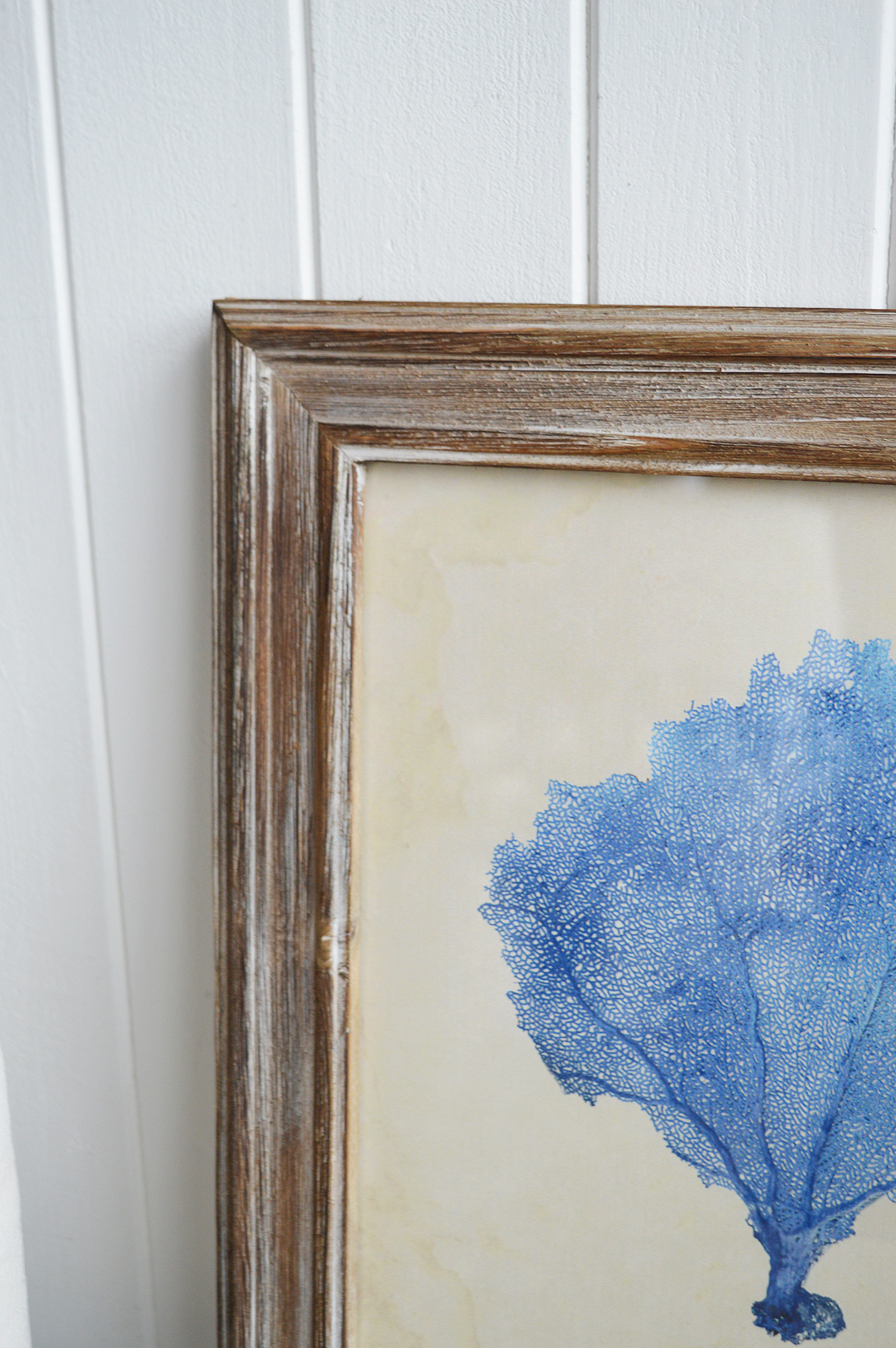 A weathered, washed wooden frame surrounds the print, enhancing its rustic, nautical appeal.