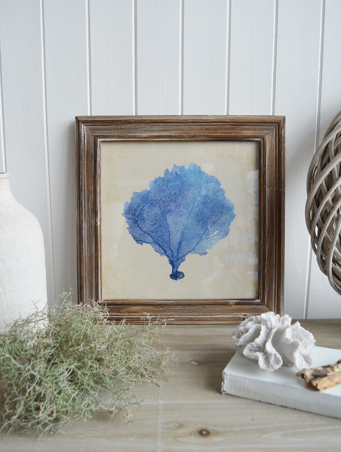 The soft, distressed tones of the frame complement the antique-style coral design beautifully.