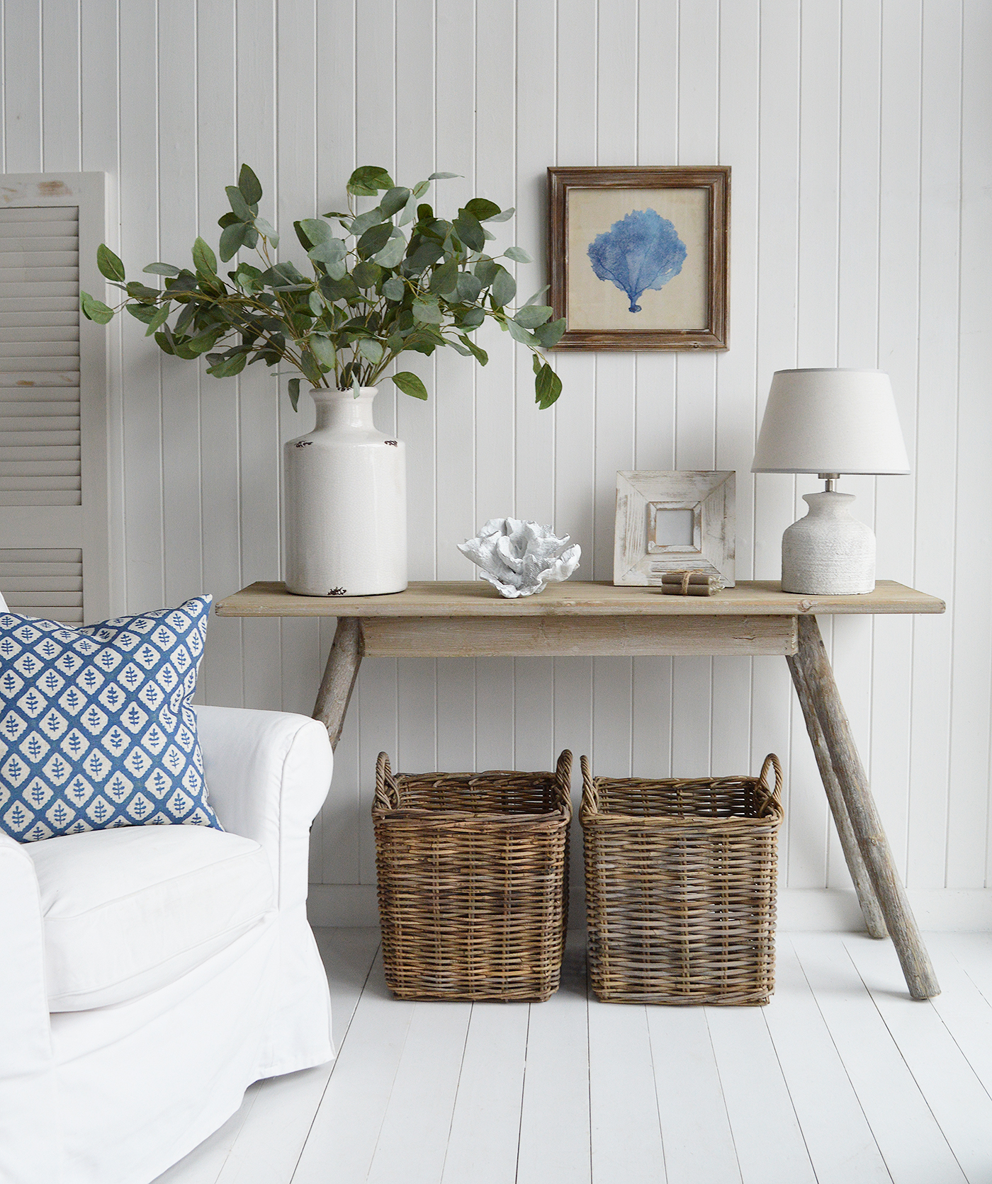 The framed print adds a timeless, ocean-inspired touch to any coastal or vintage-themed space along with the rustic driftwood conaole table with baskets underneath for extra storage, warmth and texture.