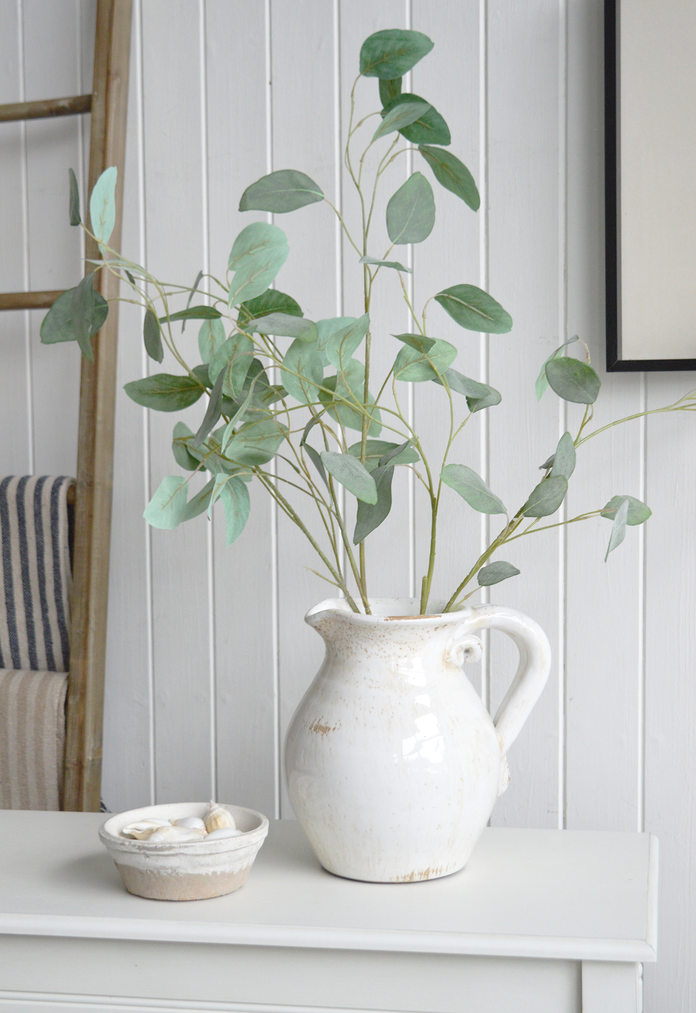 Crafted with a distressed finish, this decorative jug brings vintage appeal to coastal interiors.
