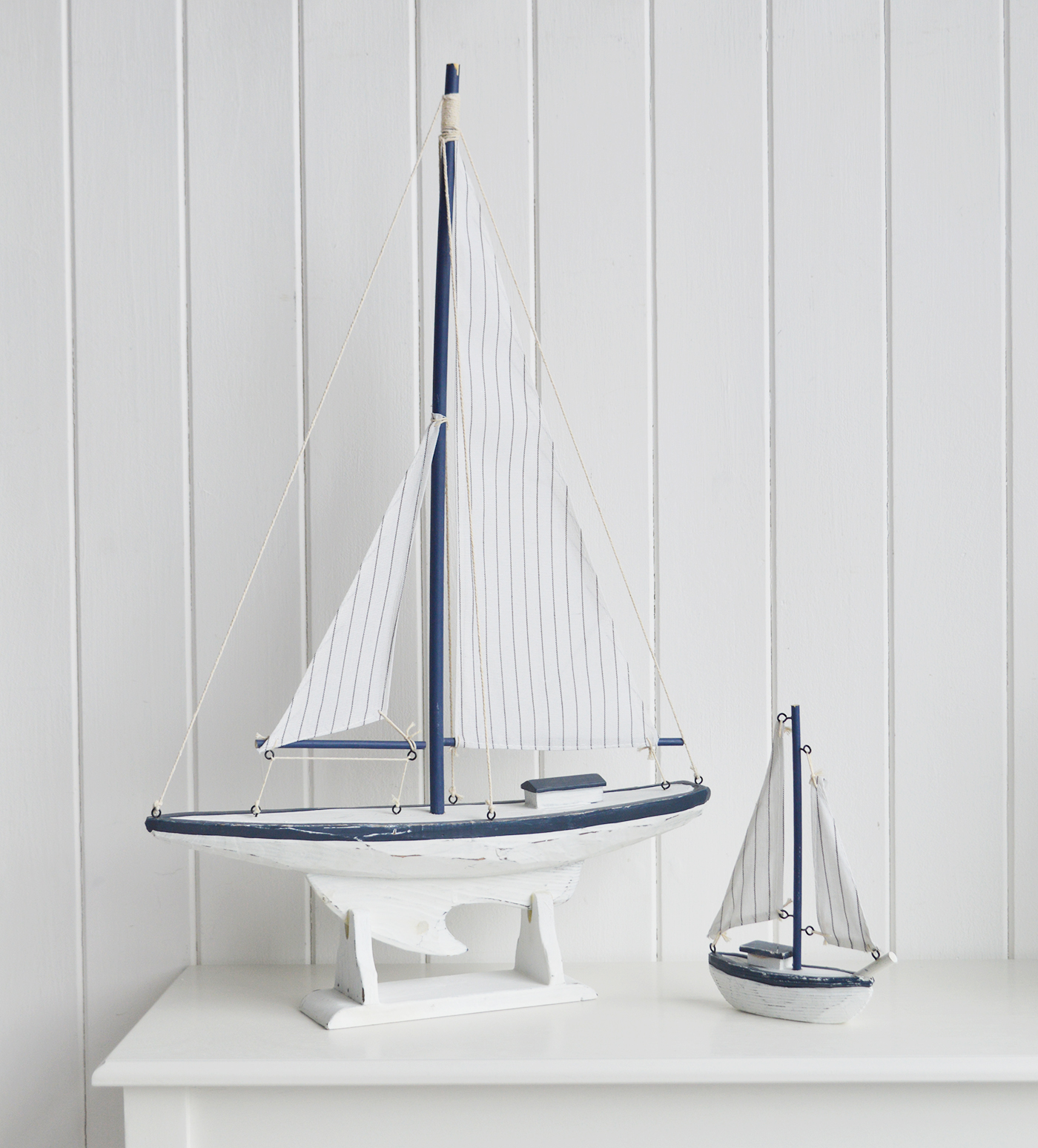 White Furniture and accessories for the home. A decorative white and blue yacht. Coastal Nautical Interior design Accessories for New England style homes and interiors