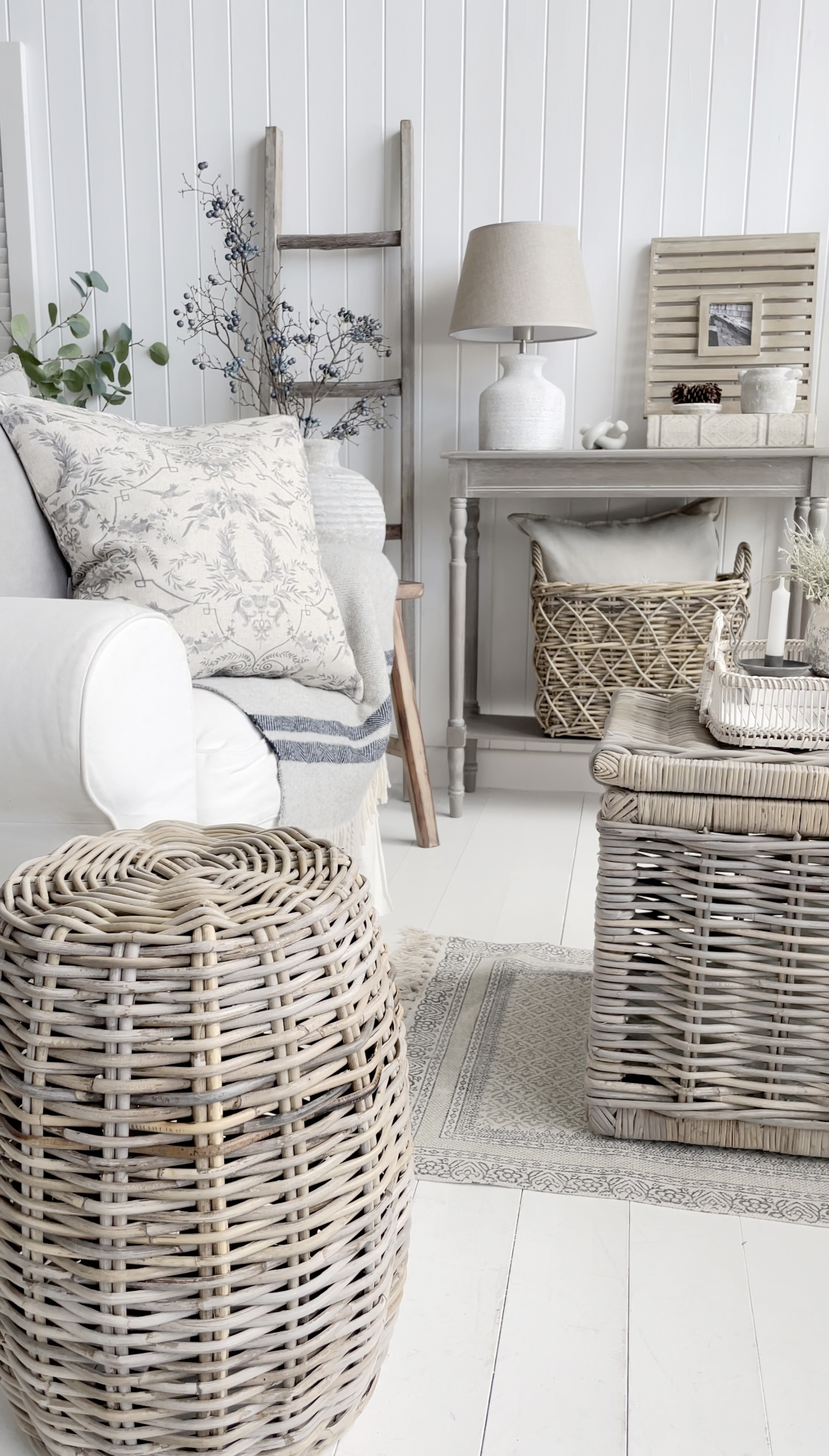 A living room in New England farmhouse style interiors with plenty of texture and natural materials