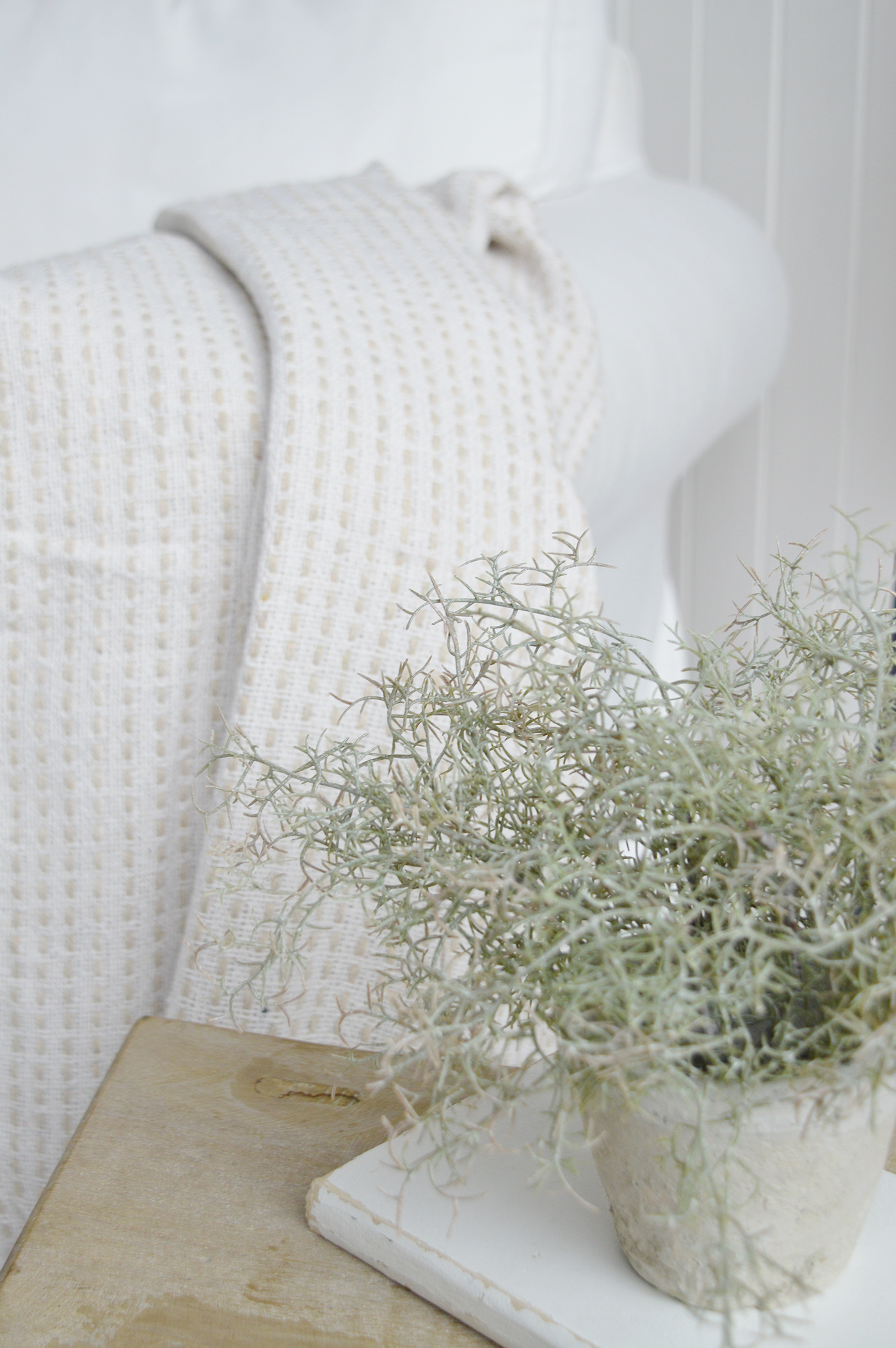 	Textural cushions and knitted throws soften modern coastal furniture beautifully