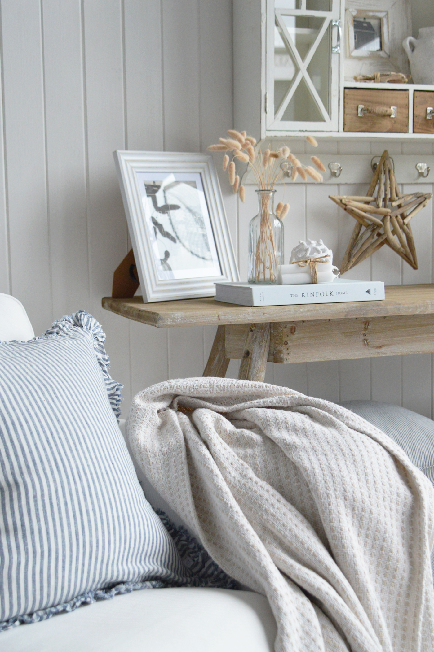 Modern country interiors with striped cushion, soft throw, and coastal chic Hamptons style accents.