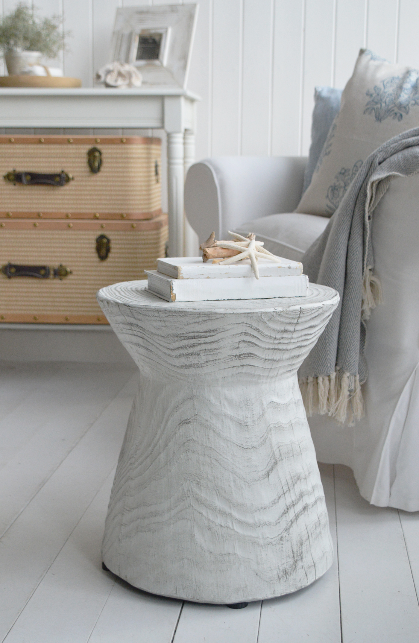 Soft white walls, painted wood floors, and natural textures form the foundation of classic coastal cottage interiors.