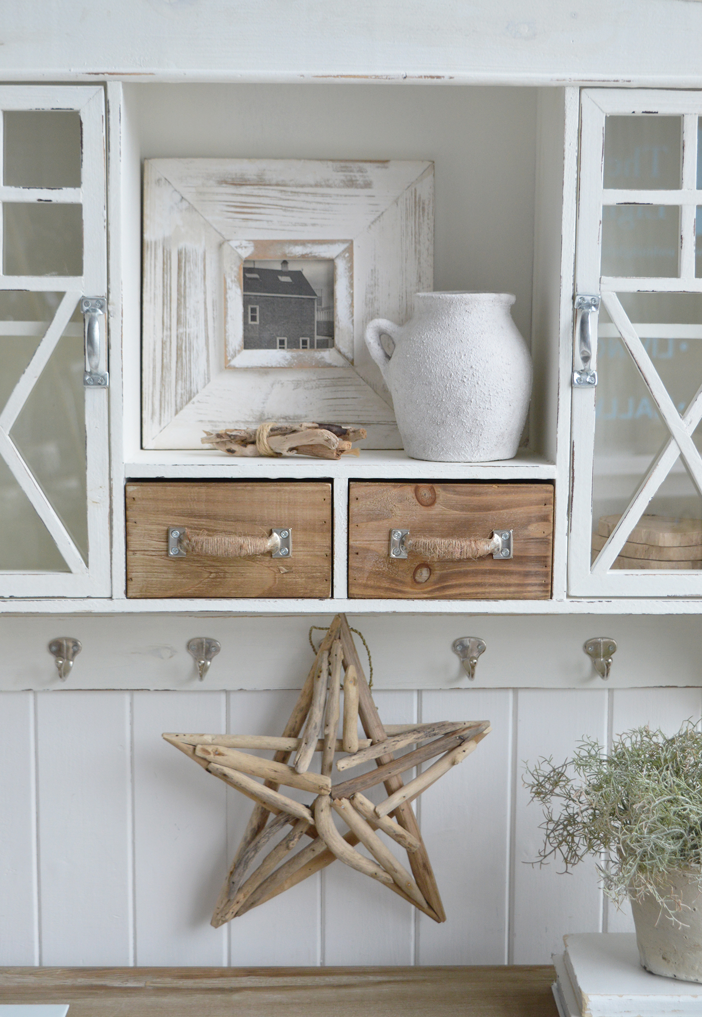 Modern country interiors with rustic cabinet, rope-handled drawers, driftwood star, and coastal chic Hamptons accents.
