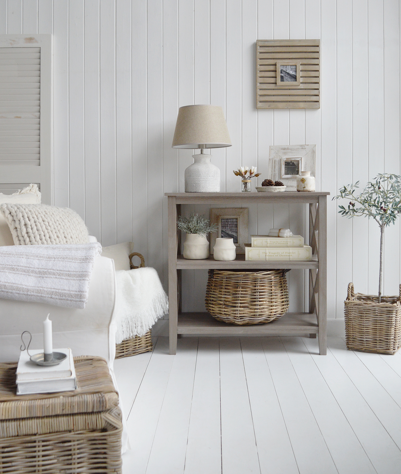 A textural console table finished in driftwood grey with 2 shelves and an X frame perfectly suited in a coastal setting