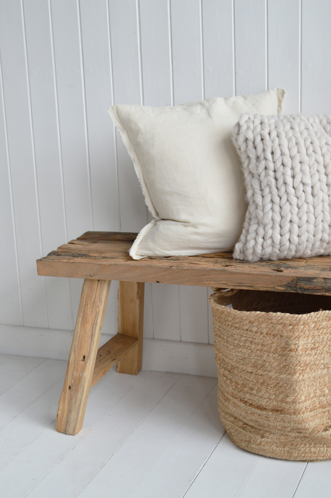 A distressed rustic wooden bench enhances coastal interiors by echoing driftwood textures and natural seaside elements.
