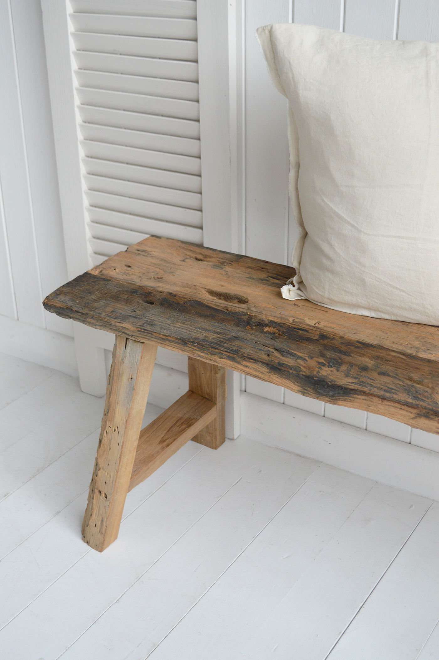 Rustic wooden bench with cushion for coastal interior decor