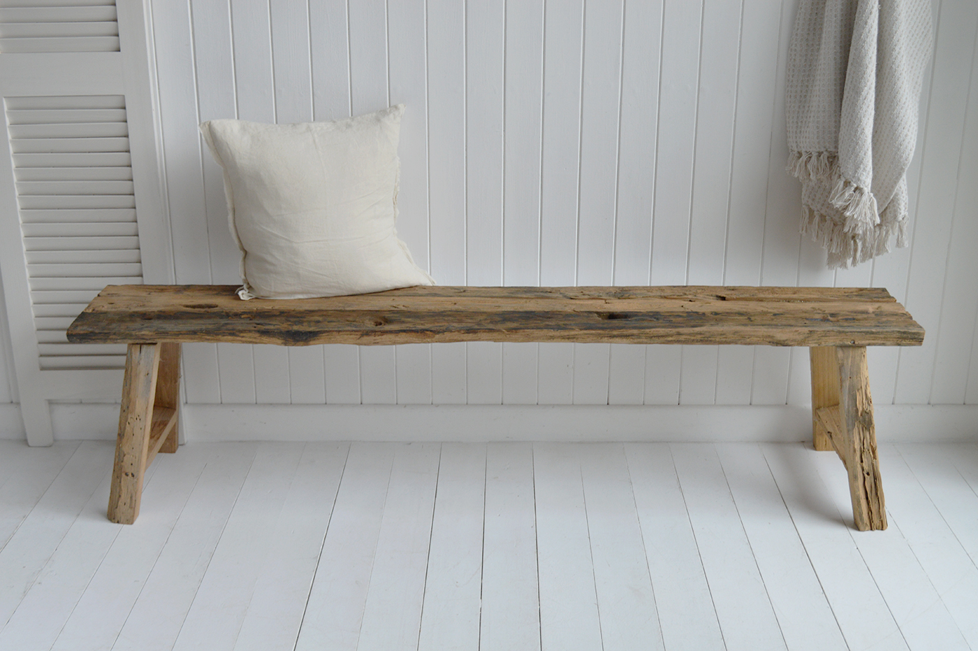 Cape Cod style reclaimed wood bench against white panel wall