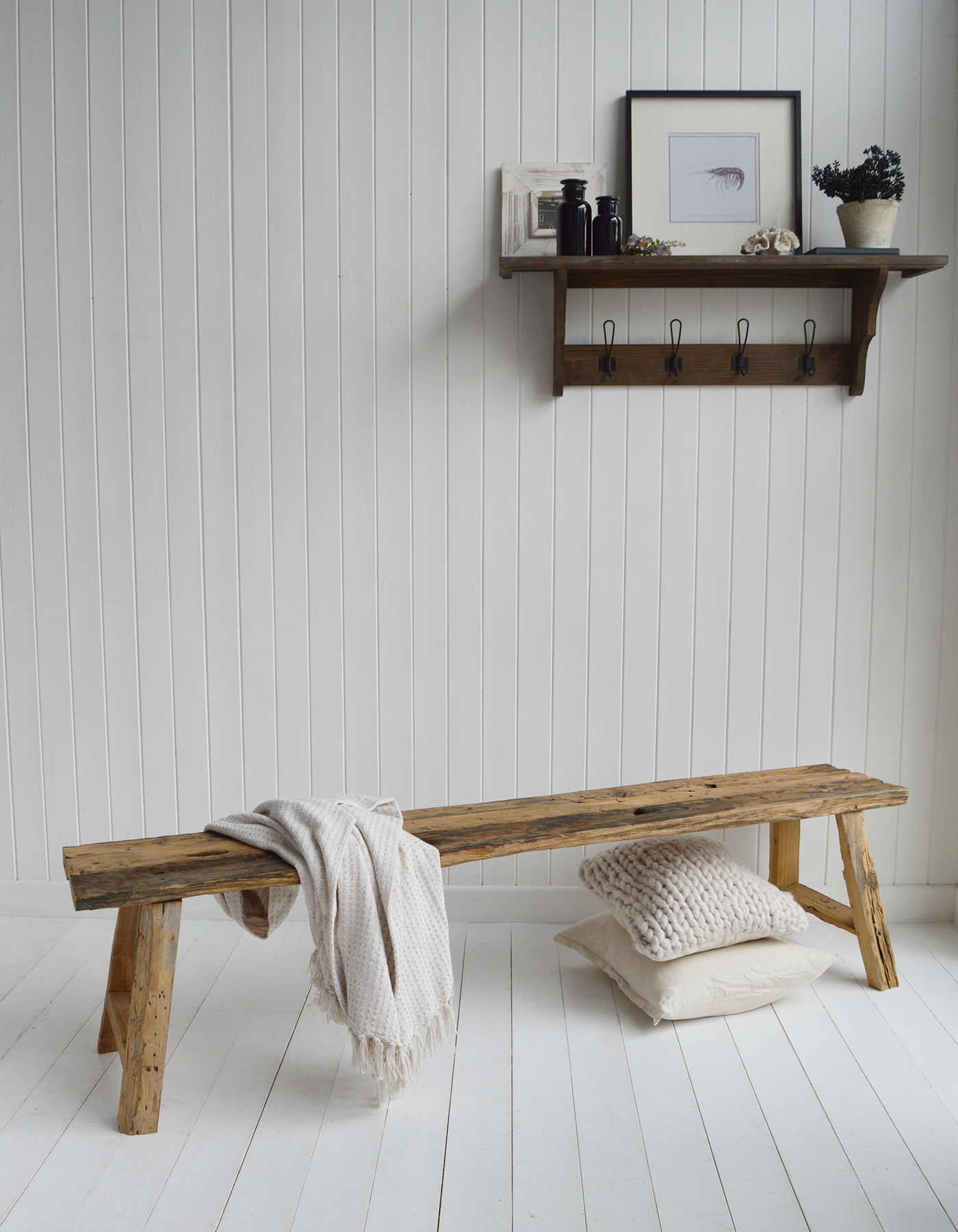 Handmade Cape Cod driftwood wooden bench crafted from reclaimed timber, styled in a bright white Hamptons-inspired coastal interior, providing rustic seating for beach-house entryway décor
