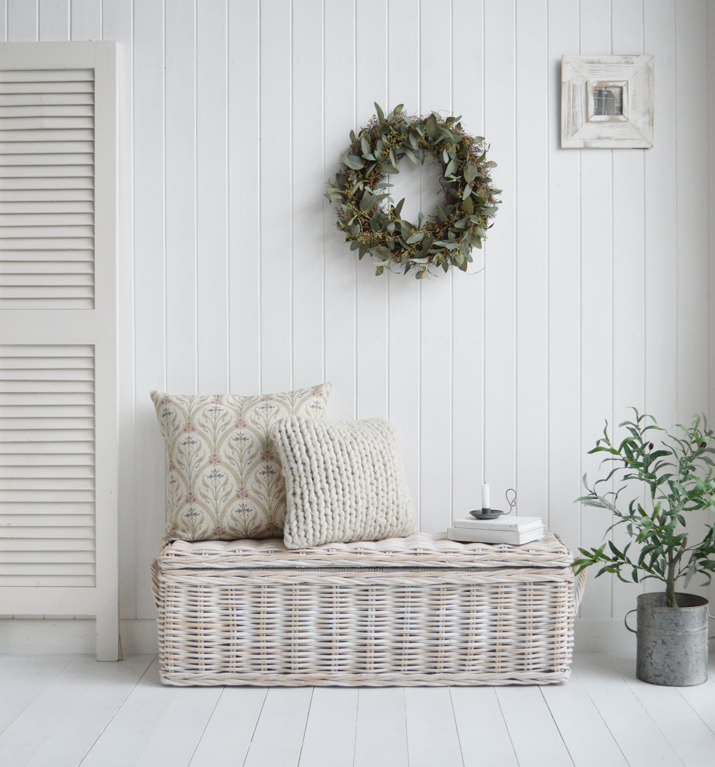 A New England white living room with the Farmington storage bench, Colton luxurious cushion, Faux Eucalyptus wreath and Olive tree in a zinc pot, a beautiful idea for a coastal style interior 