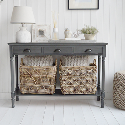 The Greyhaven Console Table in Weathered Slate brings refined New England style to hallways and living spaces with its elegant shape and softly weathered charcoal finish