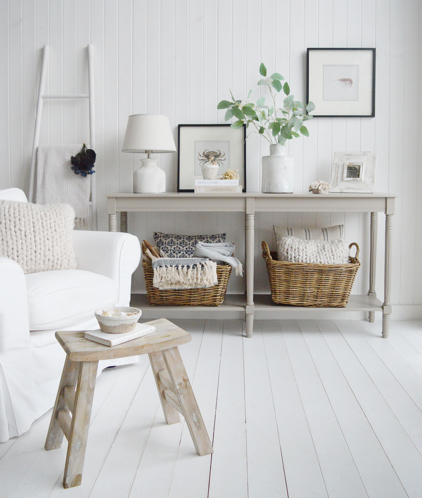 This beautifully styled neutral living room with shiplap walls, woven baskets, and a soft white console table captures the relaxed elegance of New England coastal interiors, blending natural textures, warm neutrals and timeless White Lighthouse style décor.