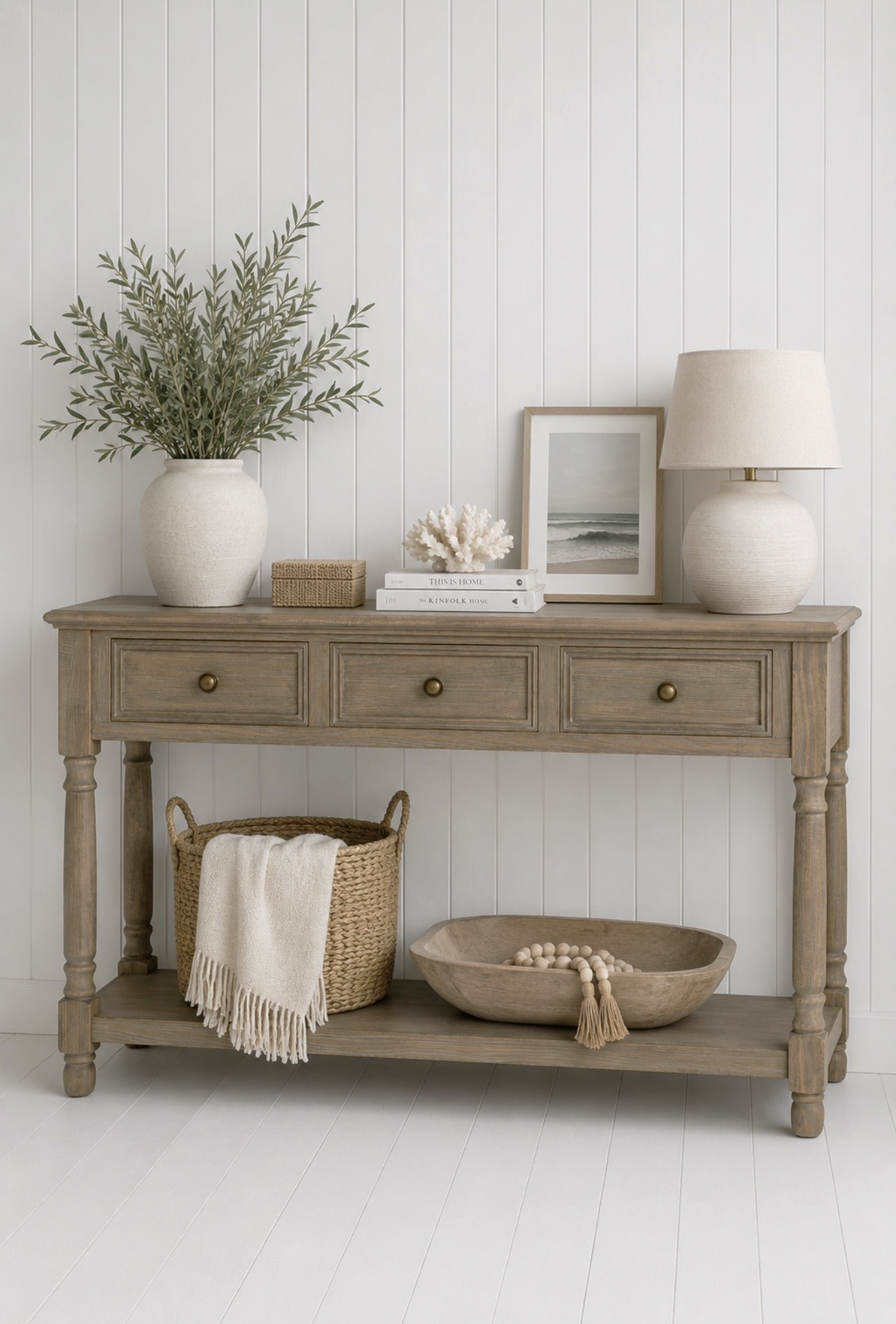 With three drawers and a spacious lower shelf, this wooden console table offers practical storage while complementing New England and Hamptons interiors.