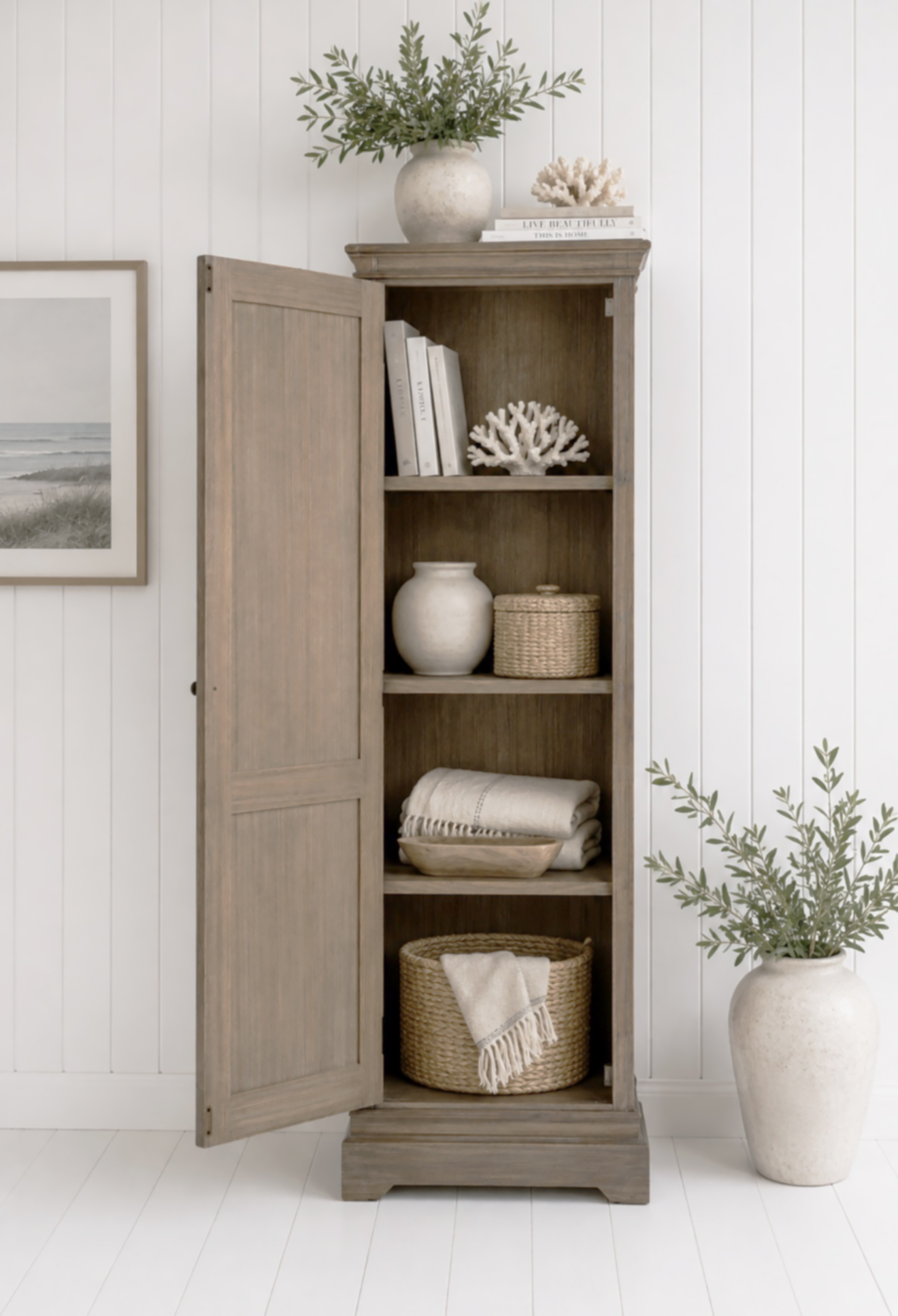 This tall wooden cabinet is ideal for storing towels, tableware, books or household essentials, making it a versatile addition to any neutral coastal interior.