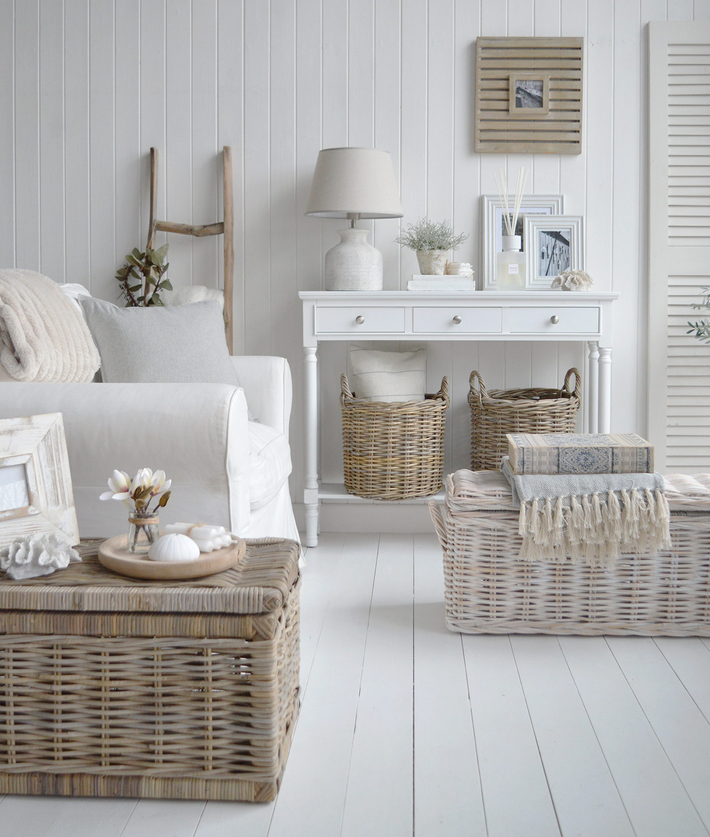 The narrow white Georgetown console table with 3 drawers for a modern farmhouse living room or hallway. Photographed with the Barnstead stone lamp and Casco bay baskets in a living room with coffee tables, a perfect idea for styling a modern farmhouse living room or hall