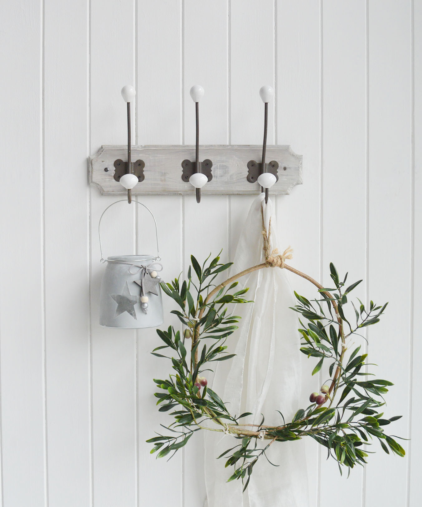 A wall mounted coat rack with three aged metal double hooks with porcelain ends on a rustic grey washed wooden backing.

The Pawtucket Range is a range of furniture and home decor made from grey wash reclaimed wood for an authentic distressed rustic look .