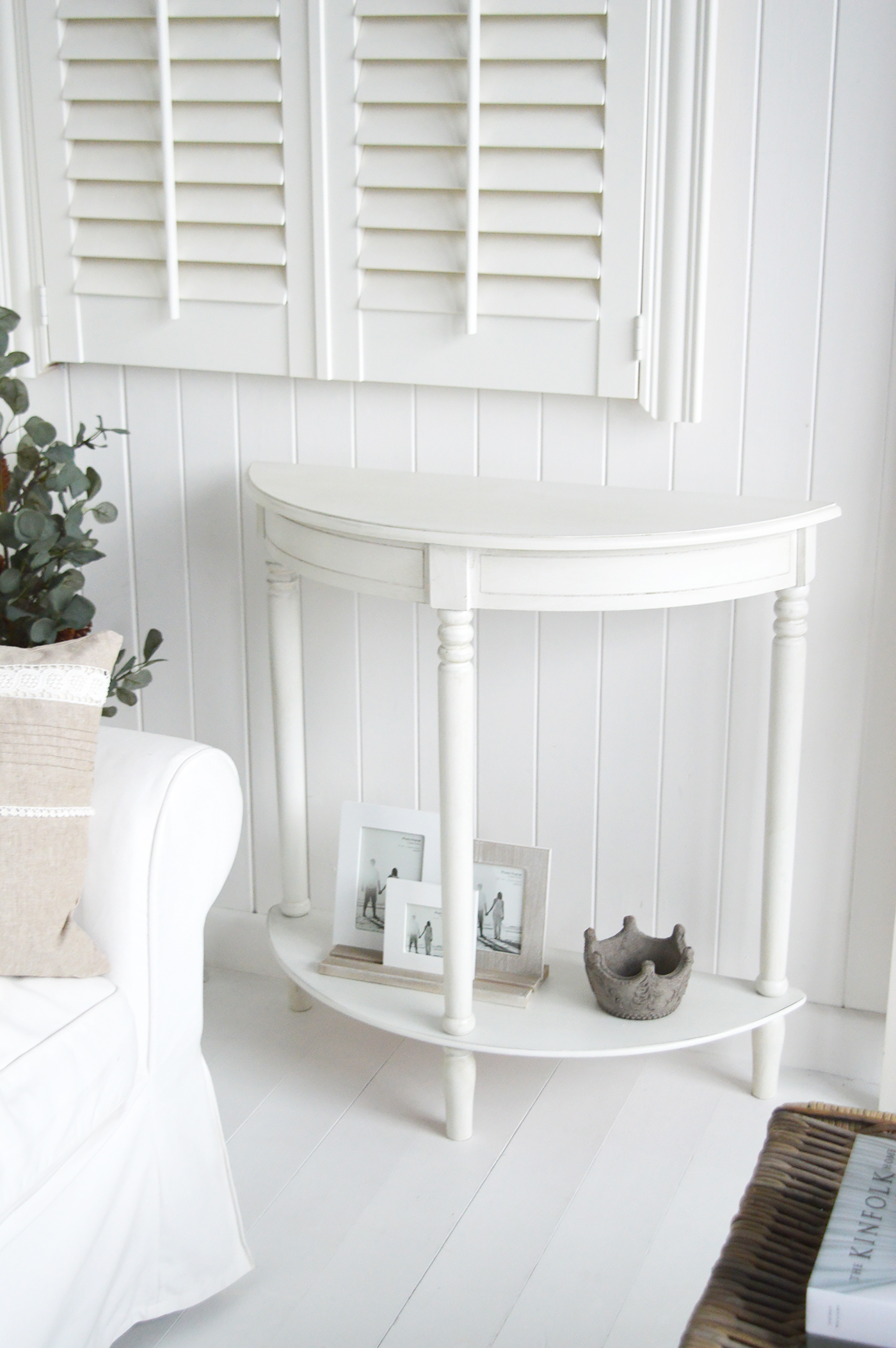 The White Lighthouse Cape Ann furniture in white. A half moon console table with shelf. White furniture enhances the reflection of natural light, which is an essential element of coastal design.